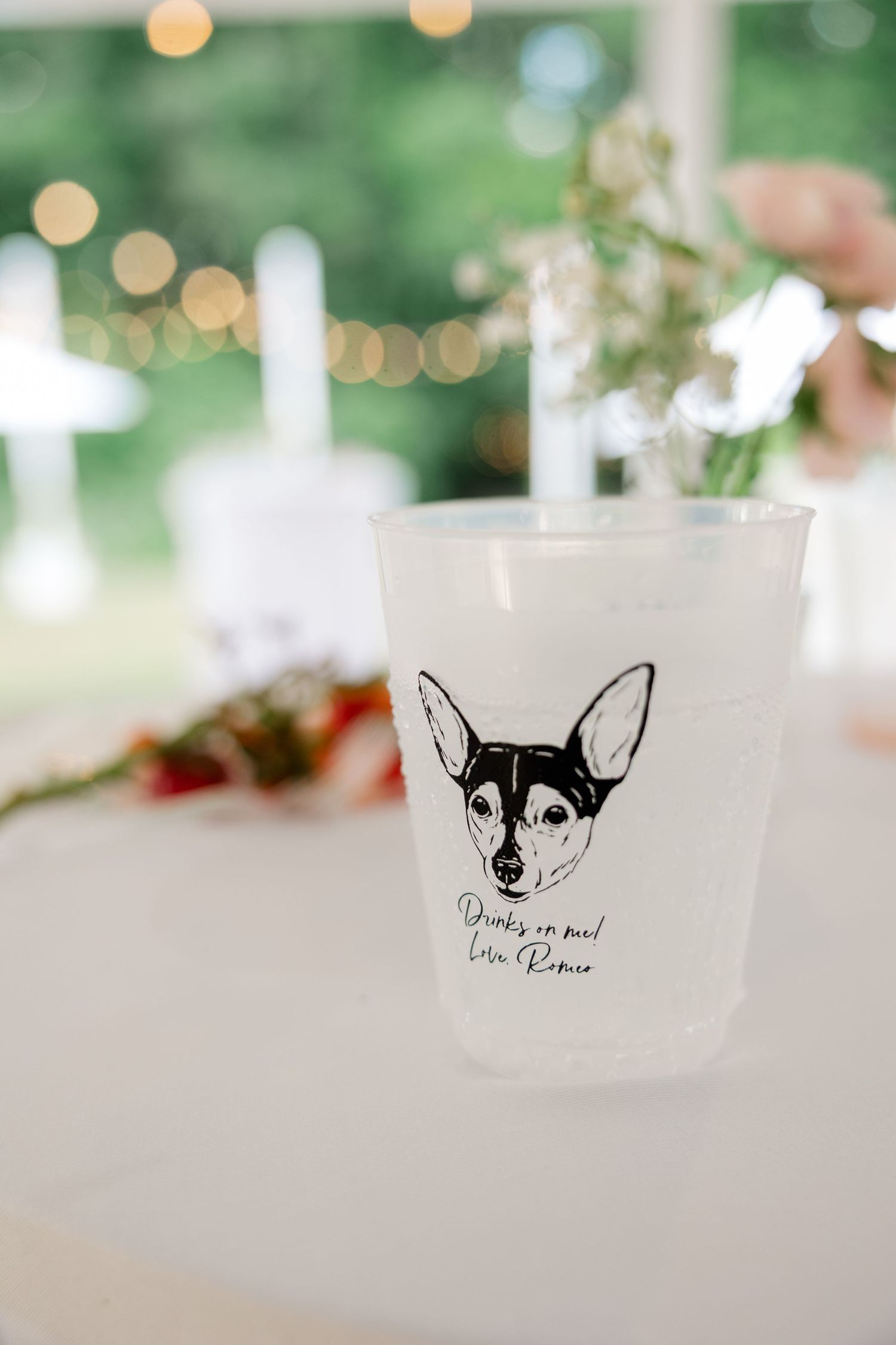 Row of frosted glasses with custom black dog illustration designs displayed at an event.