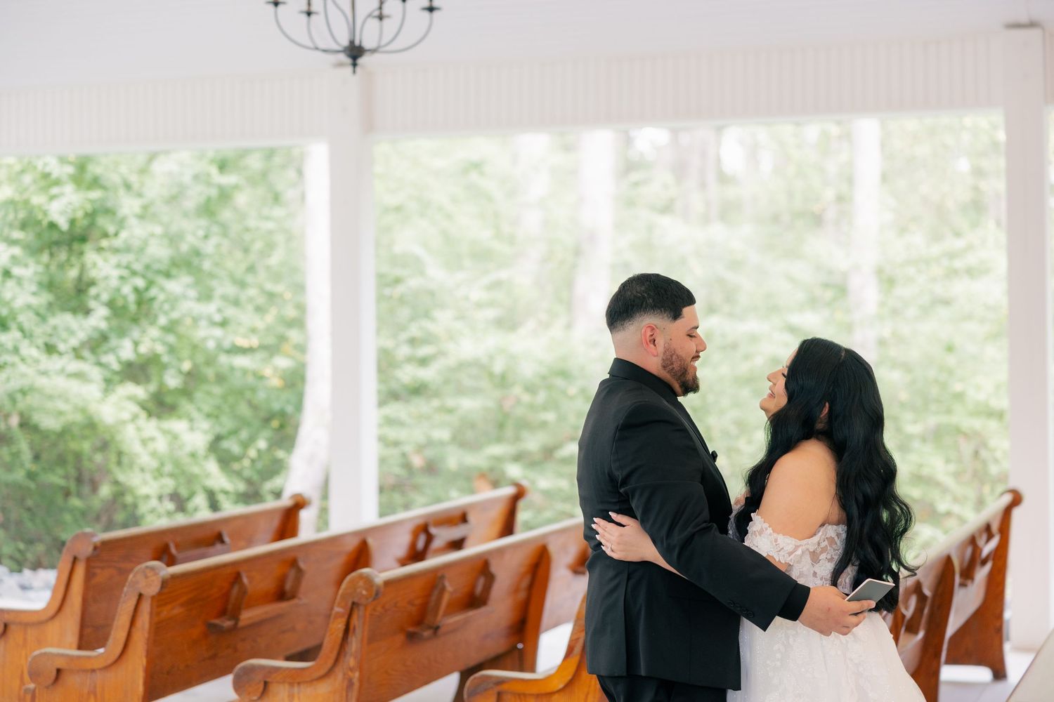 A romantic moment captured in a chapel with wooden pews and natural lighting.