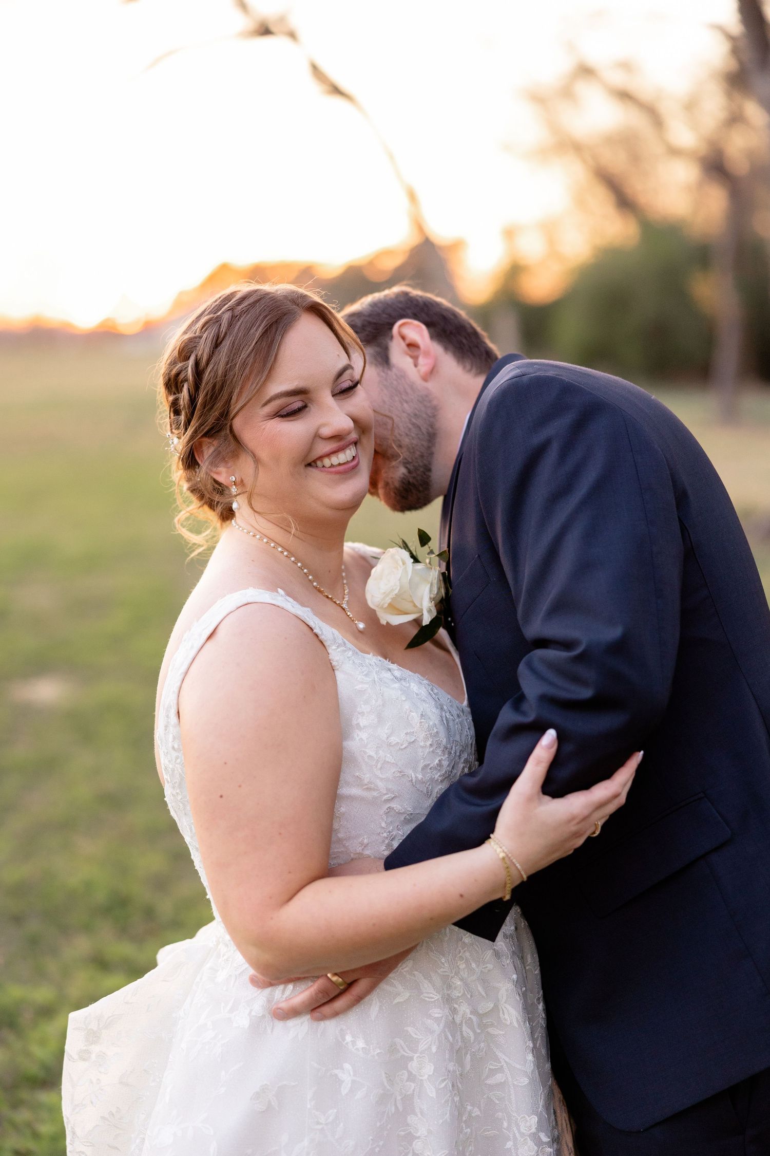 Romantic moment between newlyweds during outdoor photo session at sunset.