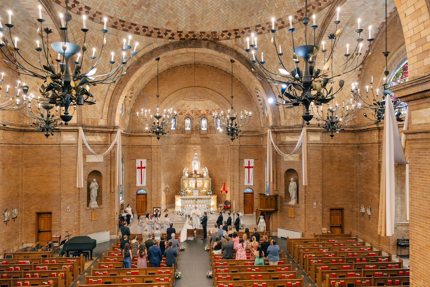 Aerial view of wedding ceremony in progress inside elegant brick church.