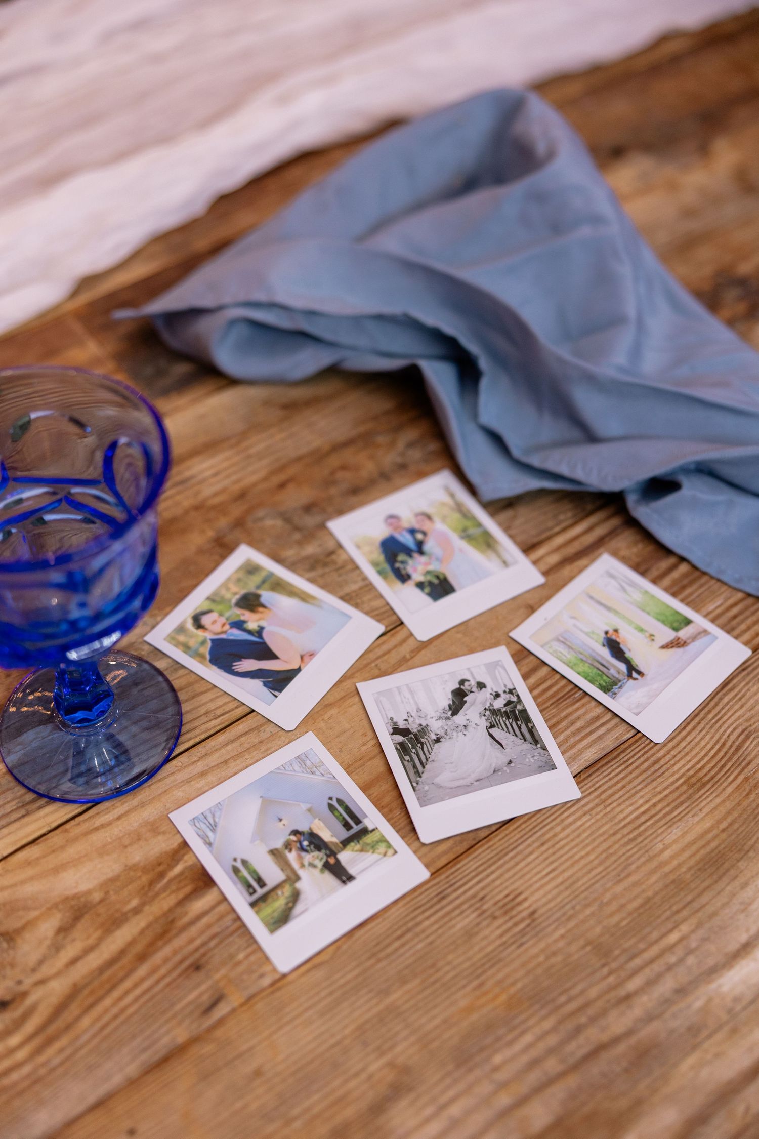 Polaroid photos and blue decor elements arranged on wooden surface.
