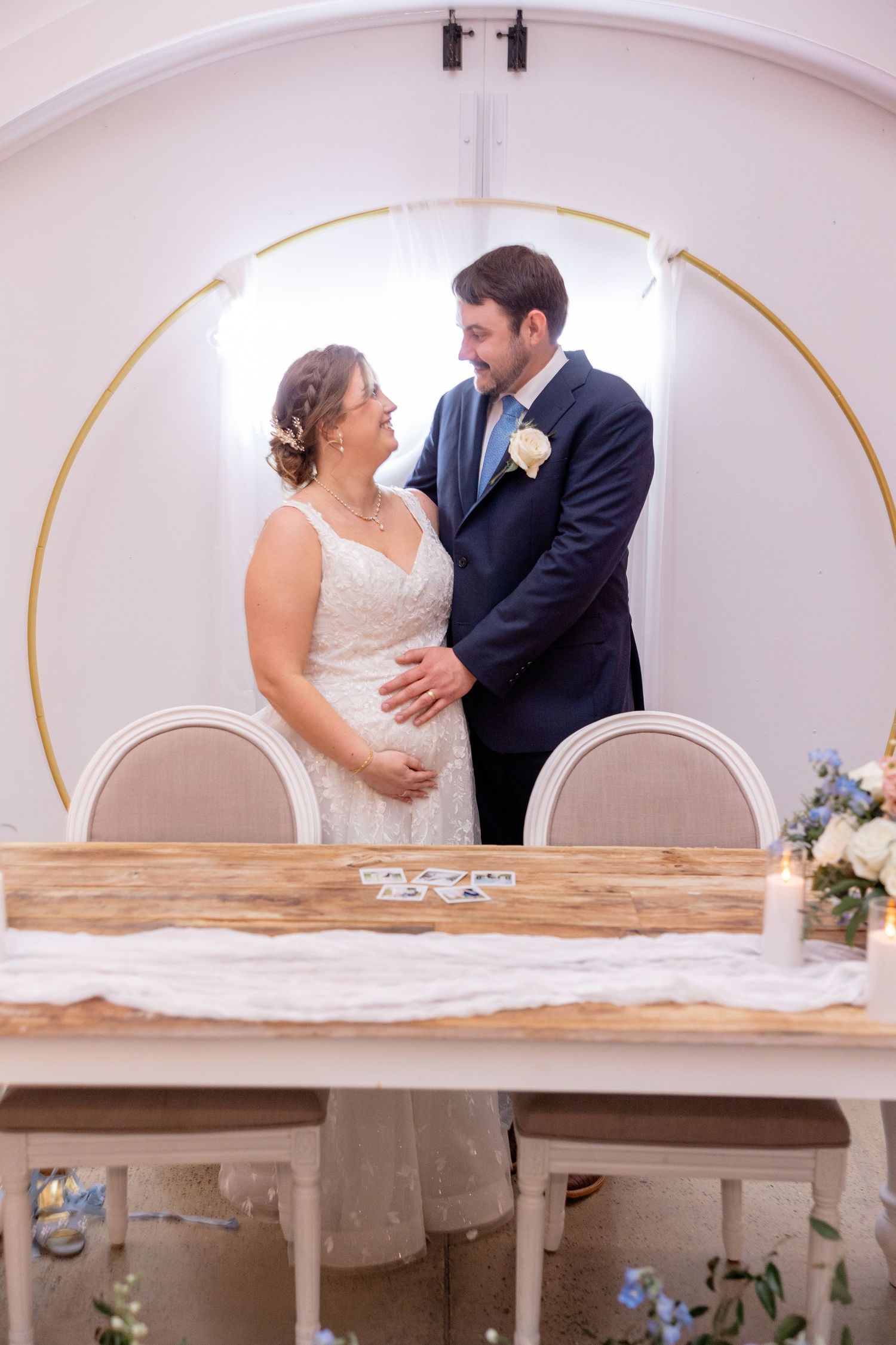 Intimate wedding moments captured against white arched walls and wooden furniture.