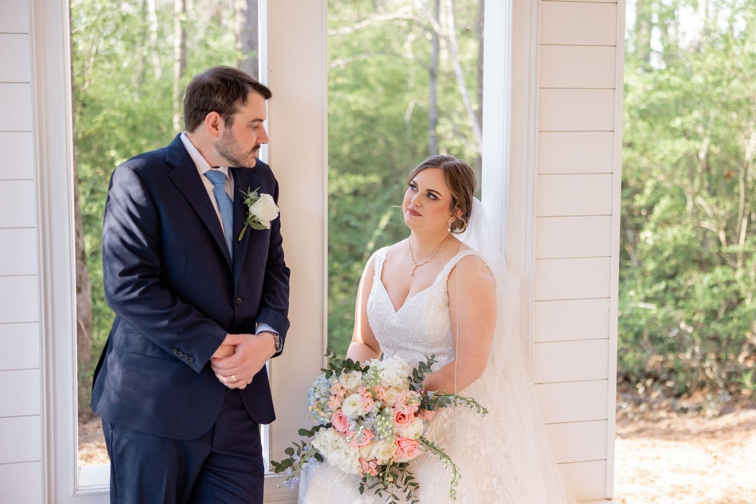 Couple shares joyful moments during their wedding ceremony in a sunlit chapel.