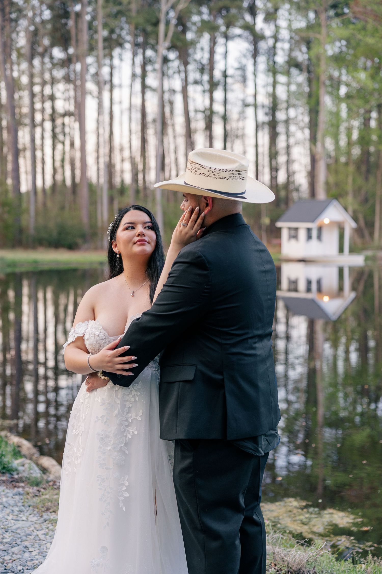 Wedding couple poses for intimate portraits among pine trees at outdoor venue.