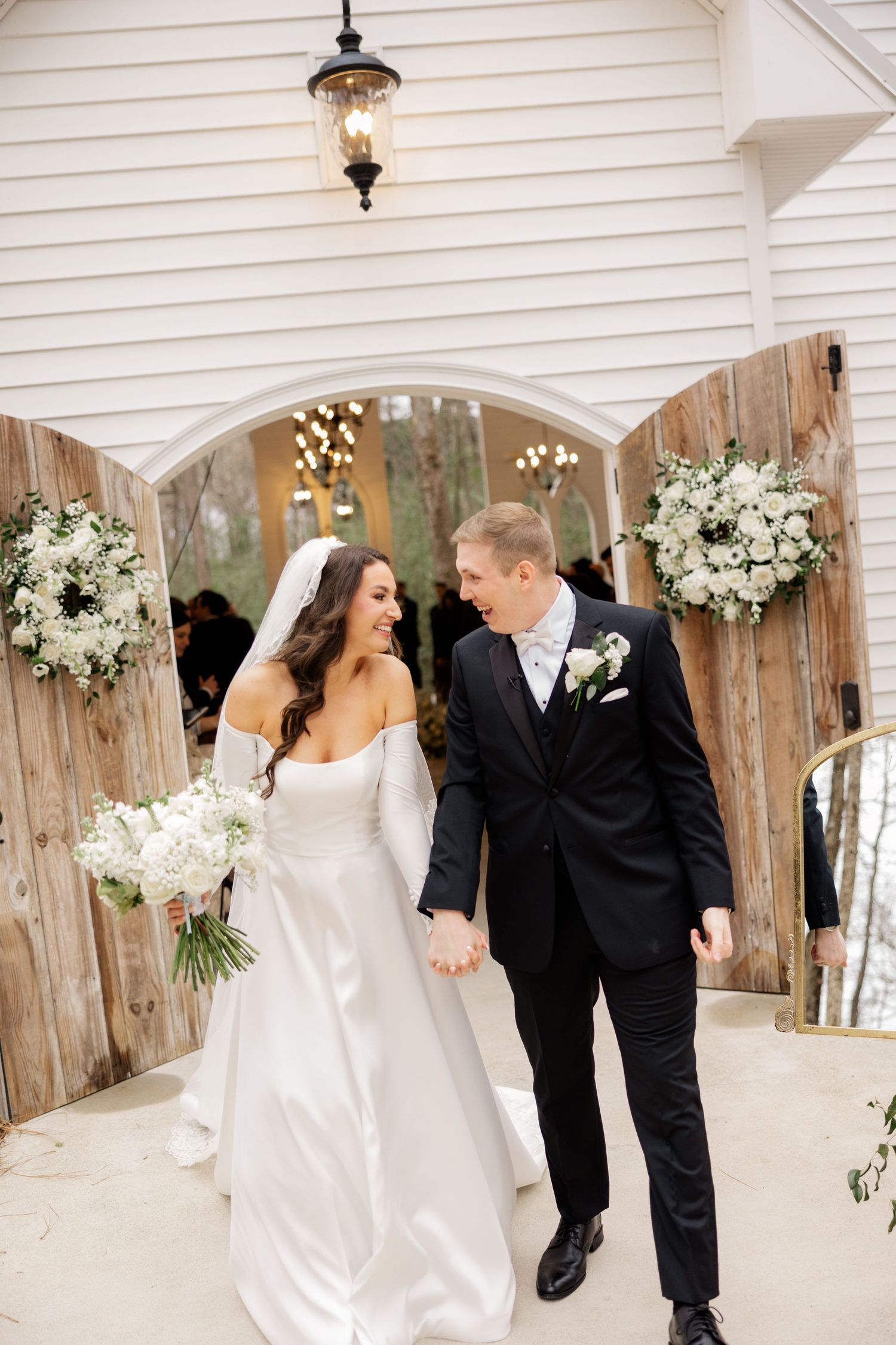 A classic wedding moment captured in a white gazebo decorated with floral arrangements.
