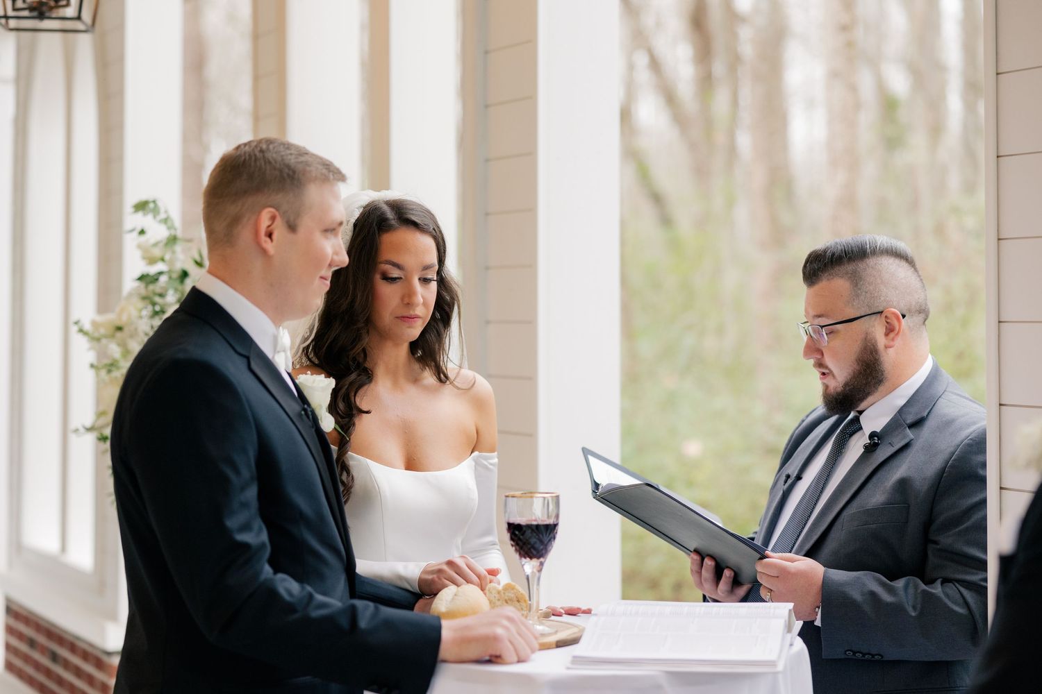 Wedding party members in formal attire gather at indoor reception venue.