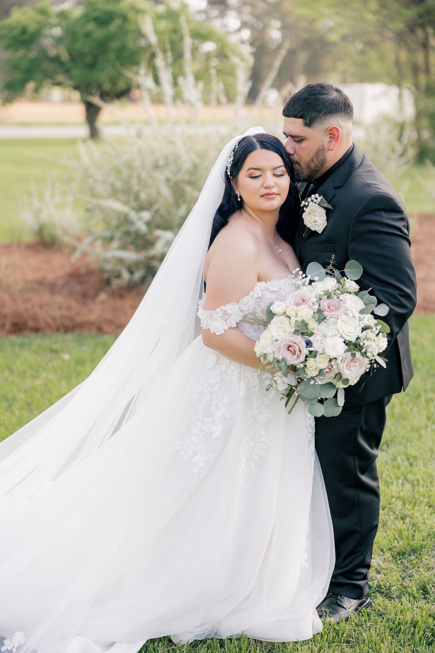 Romantic wedding portraits captured in a lush garden setting with soft natural lighting.