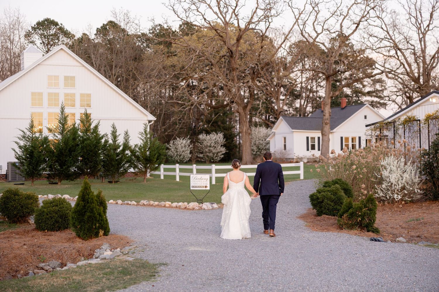 Wide angle view of a white chapel and grounds during a wedding day.