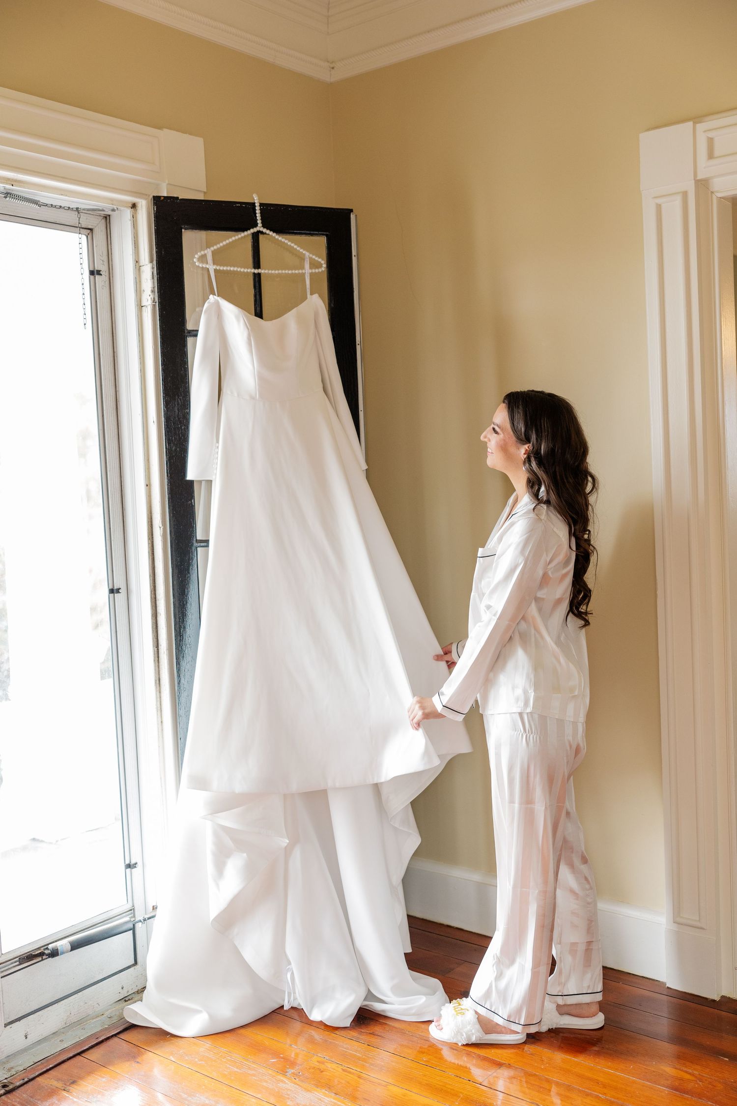White wedding dress displayed in sequence against beige walls showing multiple angles in natural window light.