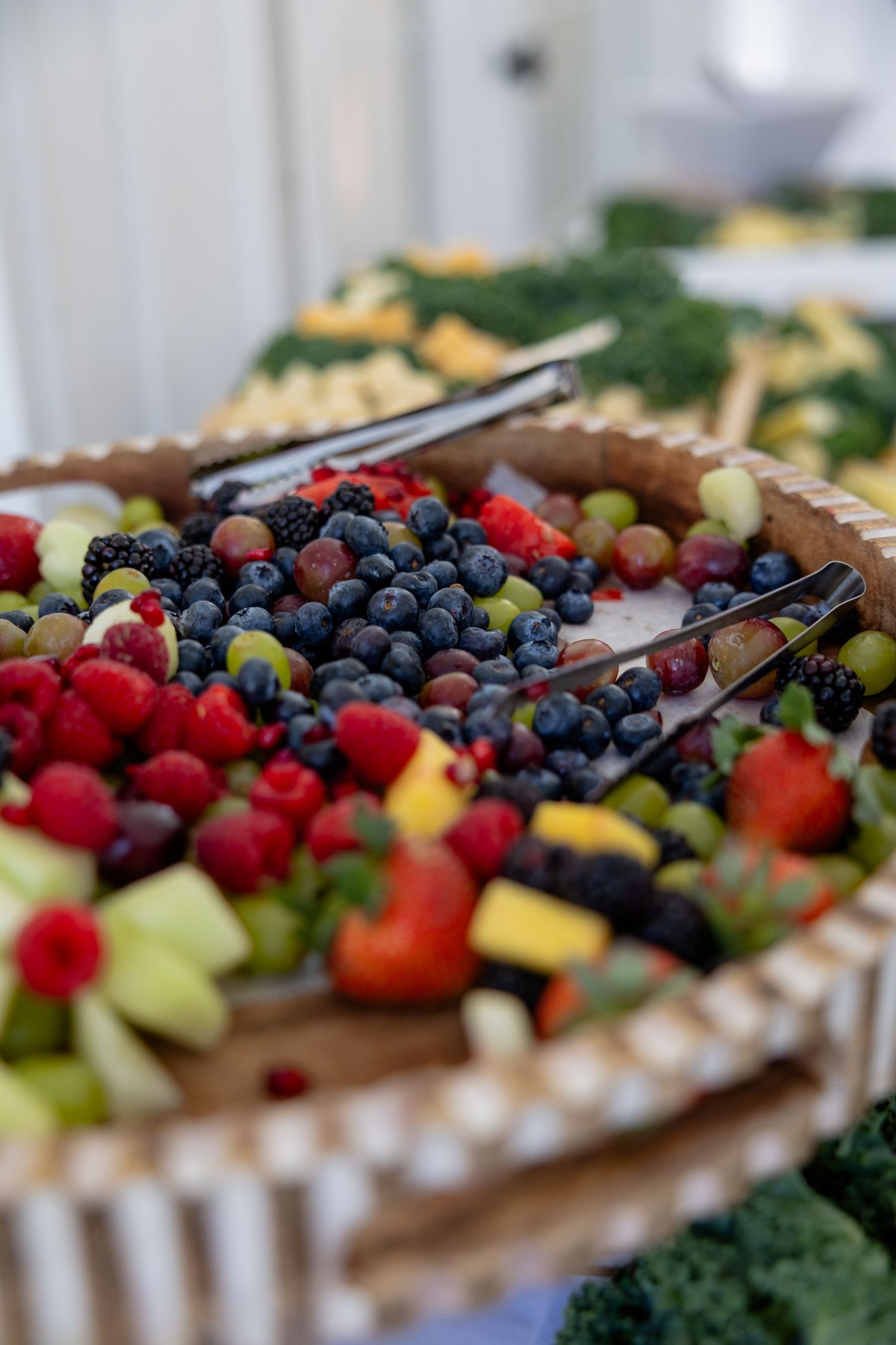 Fresh fruit and berry platter featuring raspberries, blueberries, and assorted tropical fruits.