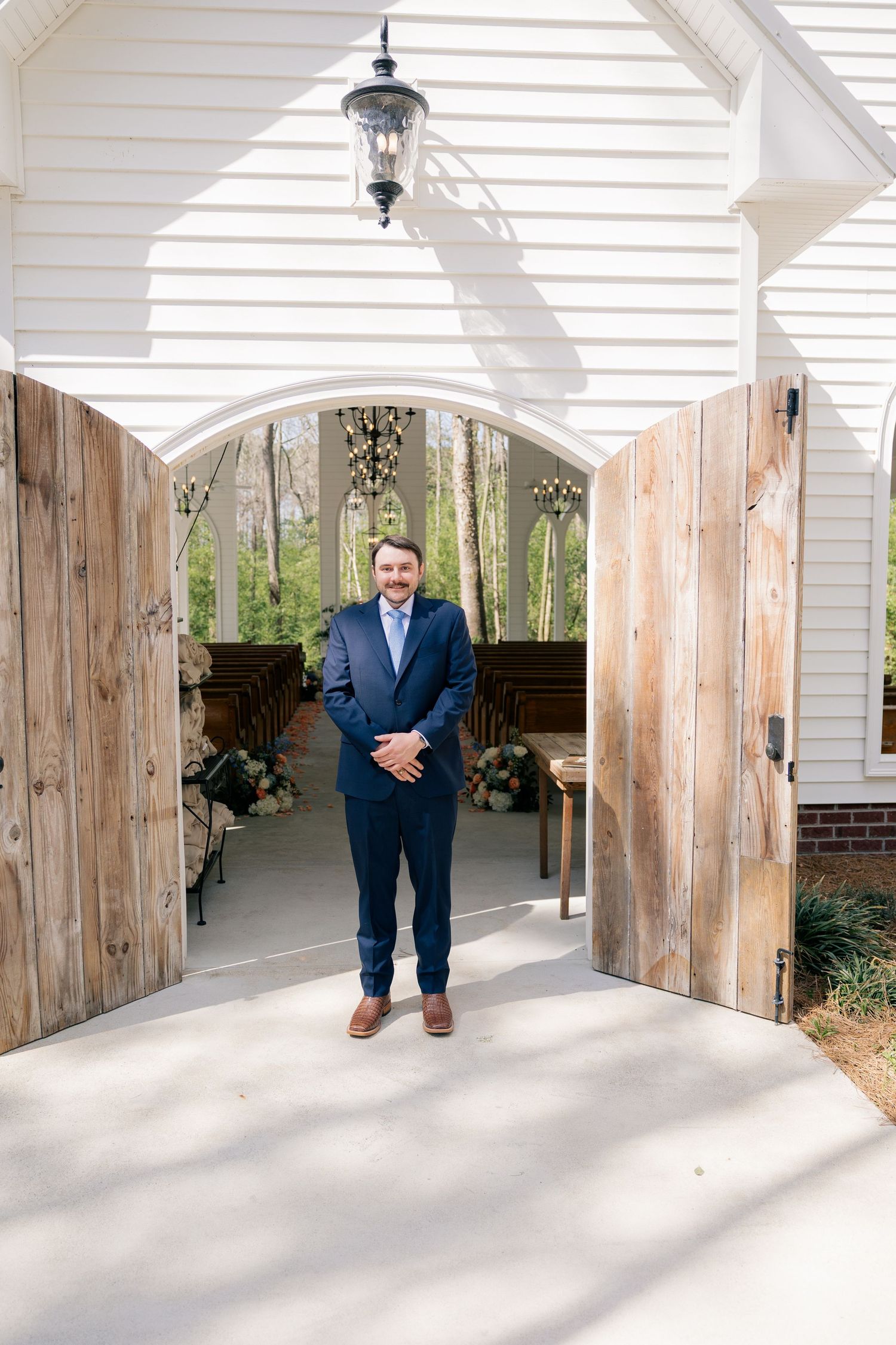 A series of photos showing a groom in a navy suit standing in a white covered porch area.