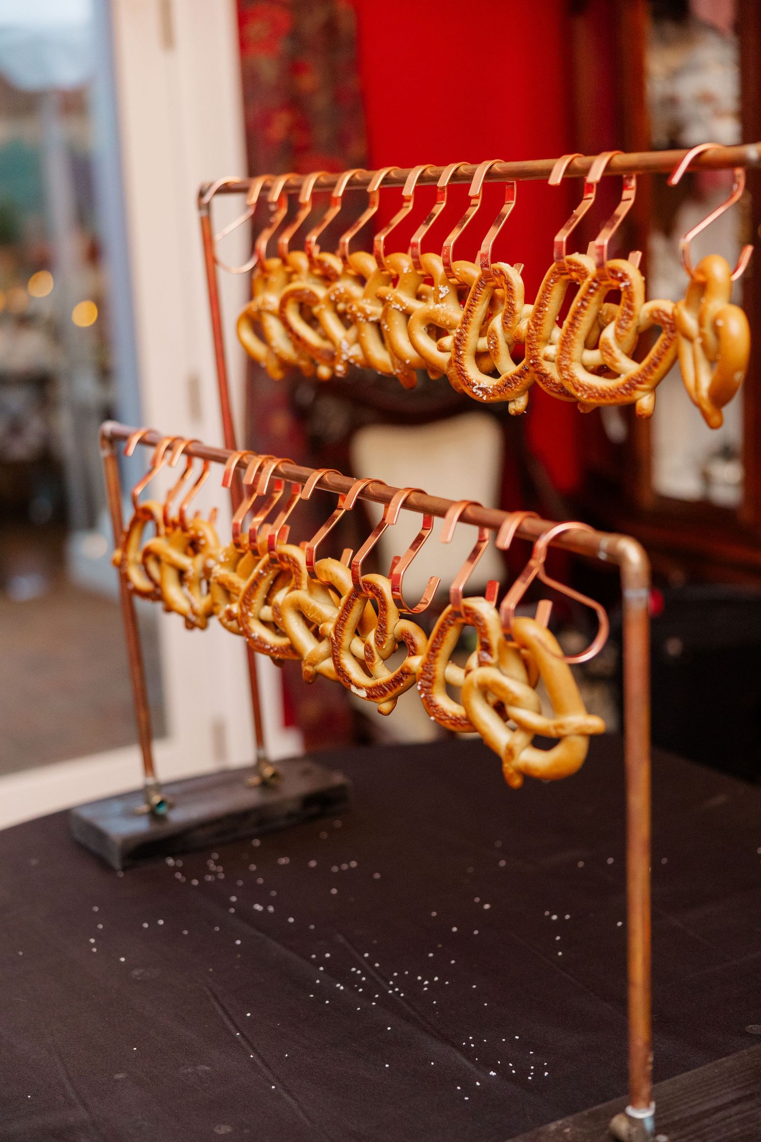 Golden pretzels hanging in rows on display at a bakery or food stand.