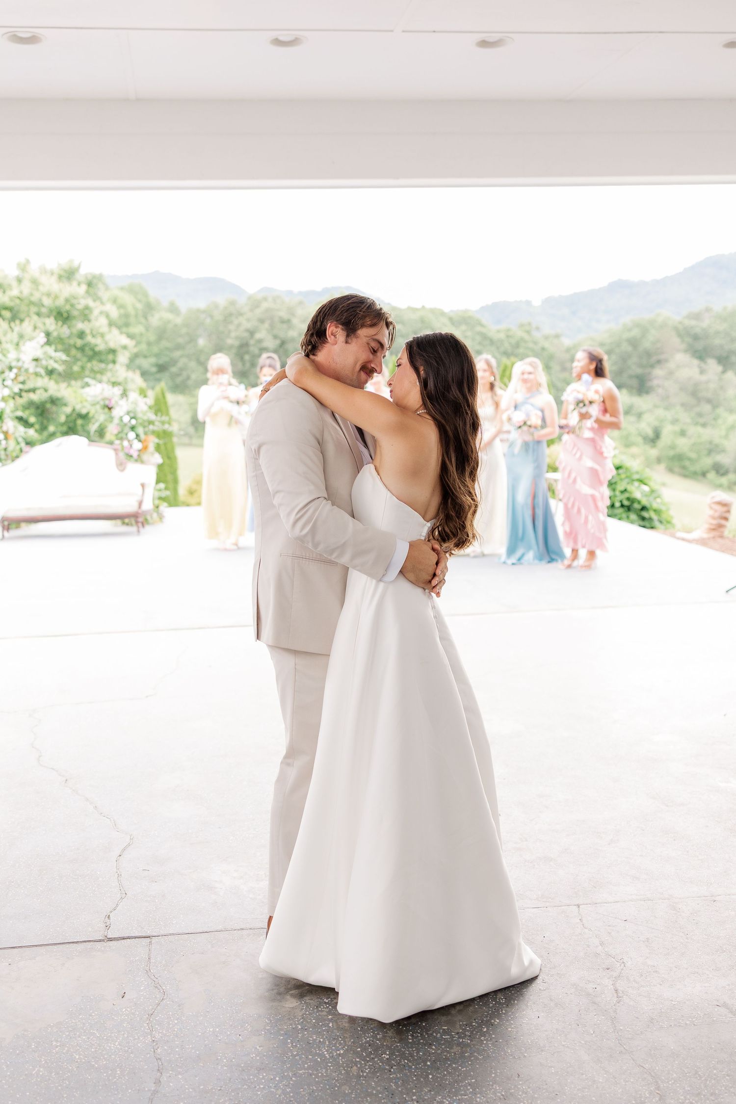 A couple shares their first dance at an outdoor wedding venue.