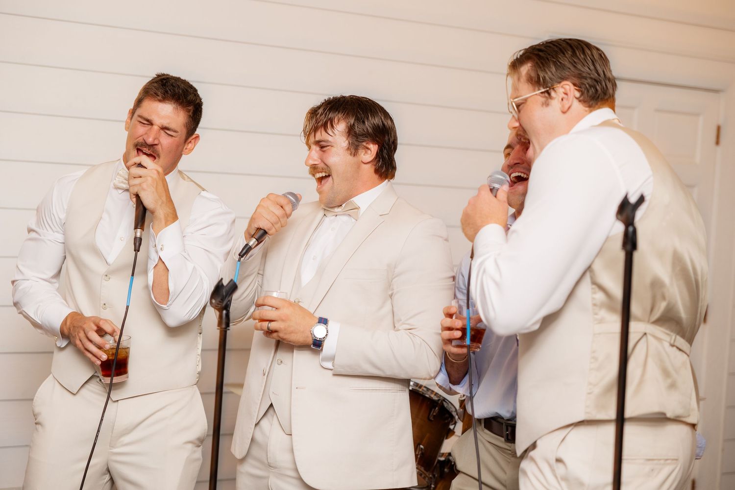 A sequence of candid reactions showing people in light colored attire laughing together.