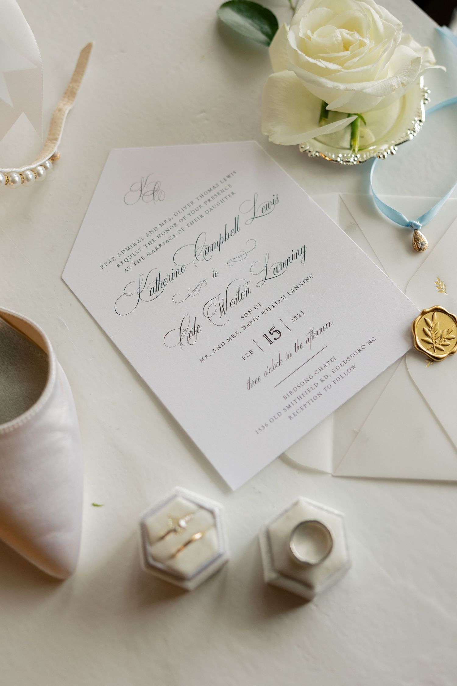 Elegant wedding invitation suite with white roses and delicate details on light background.