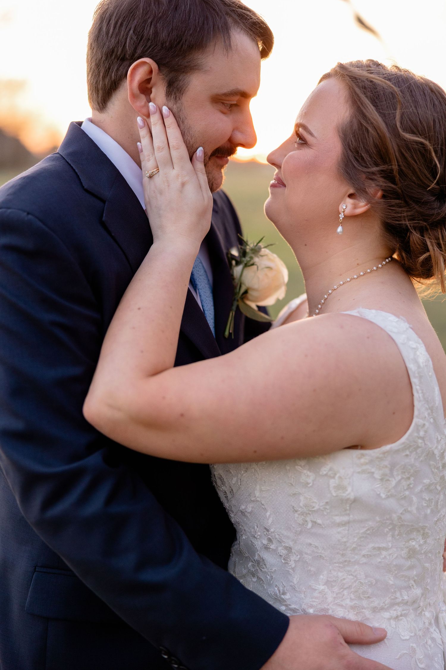 A romantic sunset portrait of newlyweds sharing an intimate moment.