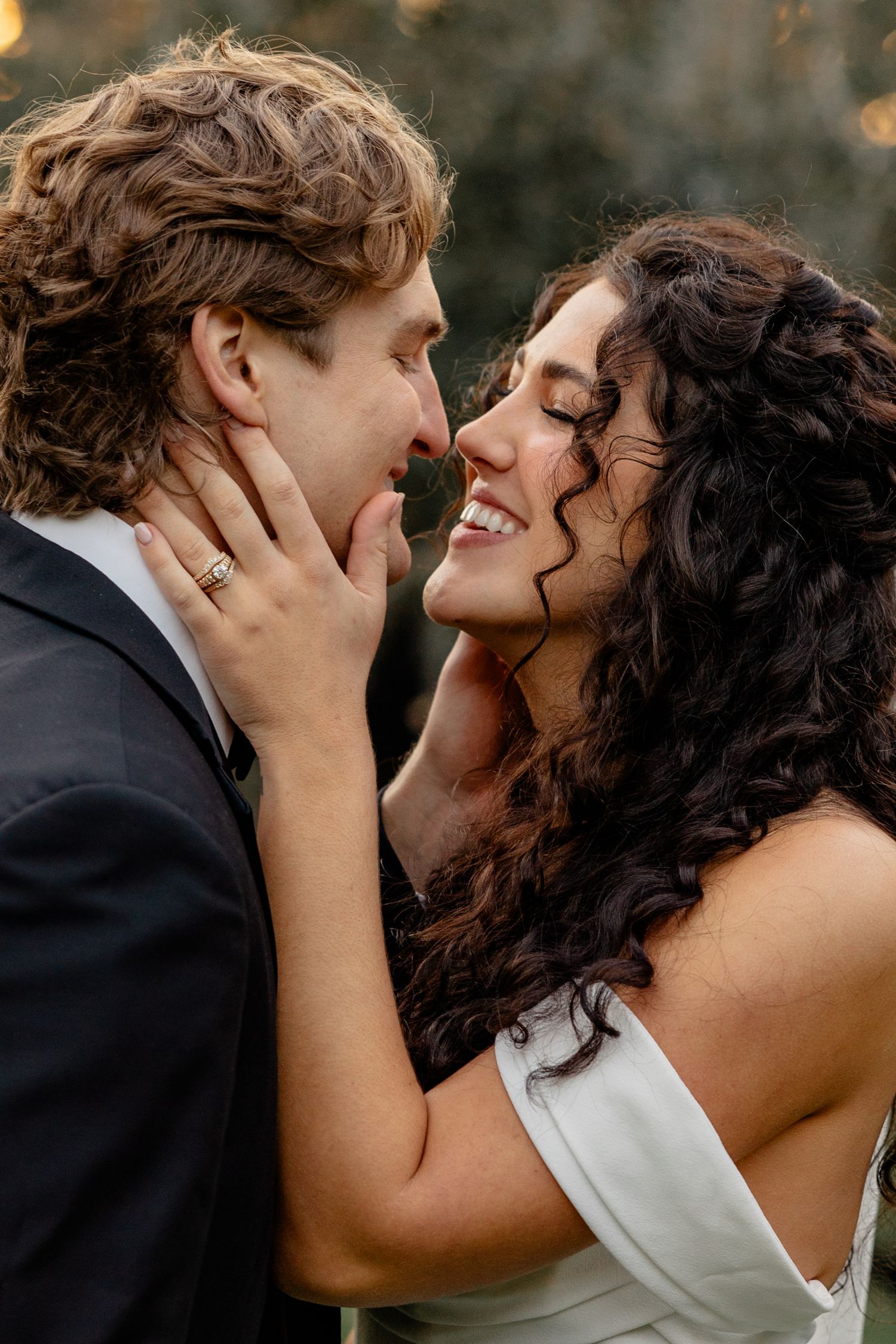 Romantic close-up moment between couple in formalwear under golden light.