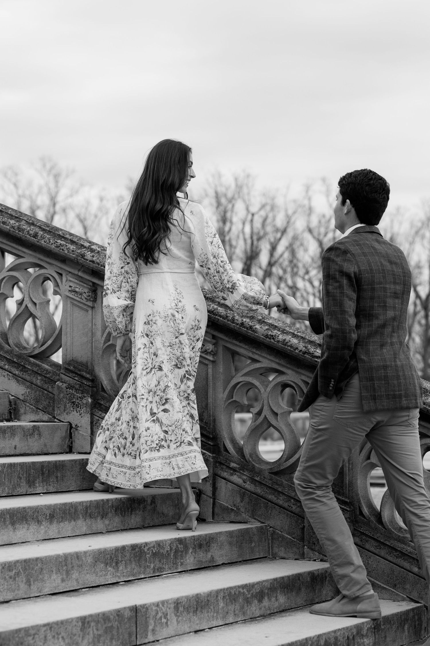 Two people ascending ornate stone steps at a historic estate in black and white photography.