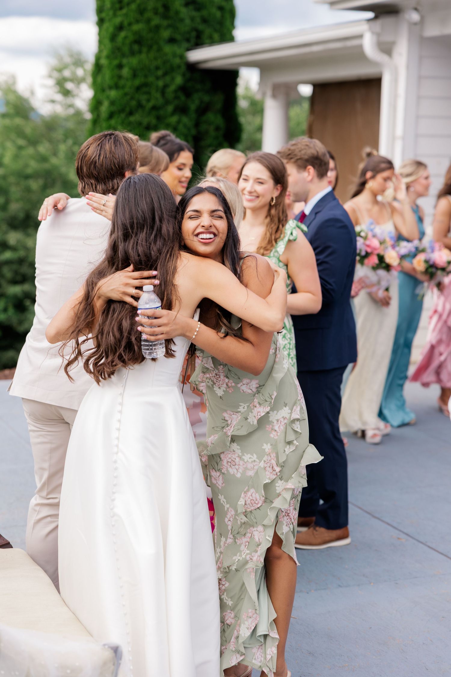Wedding guests celebrating and dancing together at an outdoor reception venue.