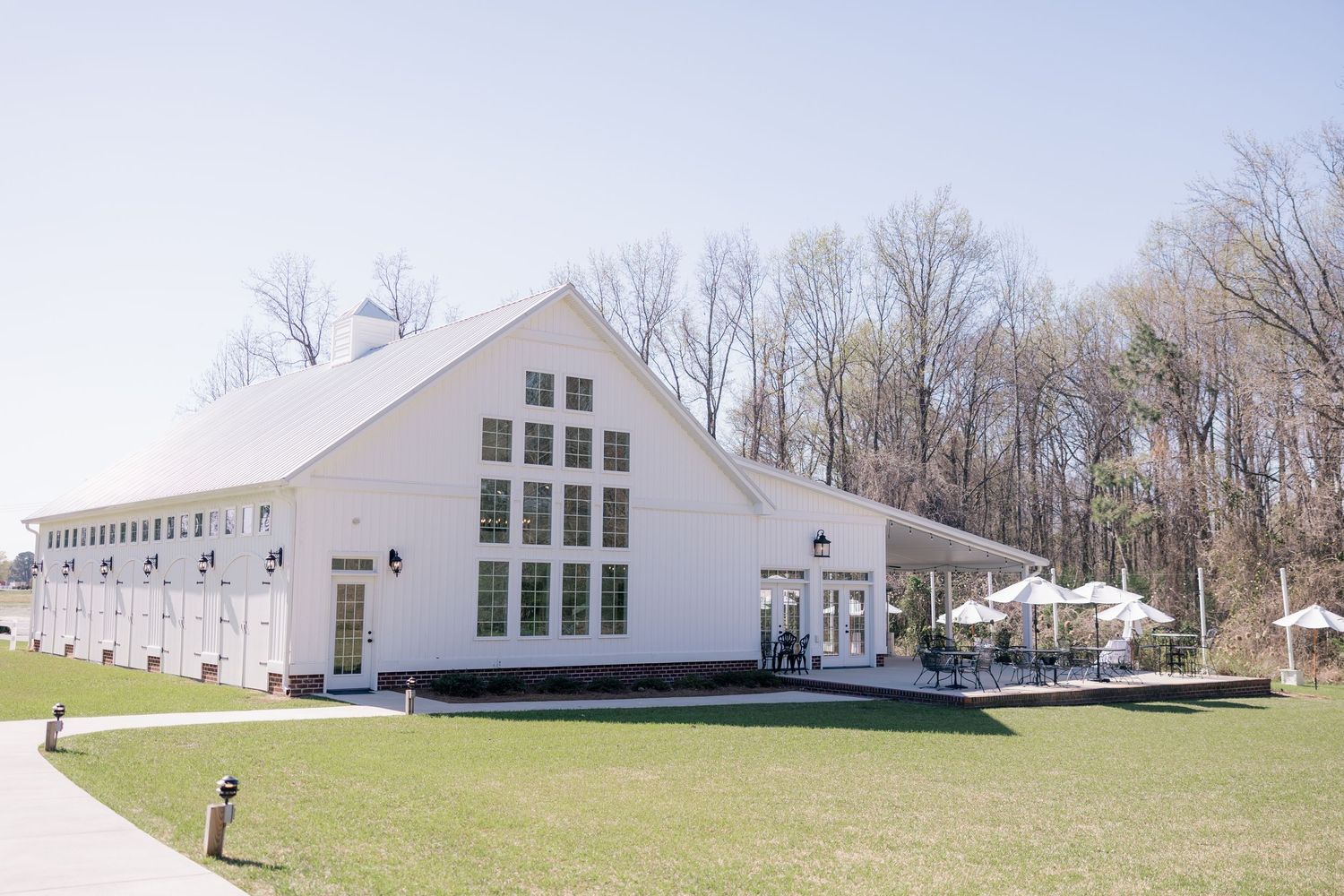 Exterior view of a modern white wedding chapel surrounded by trees and landscaping.