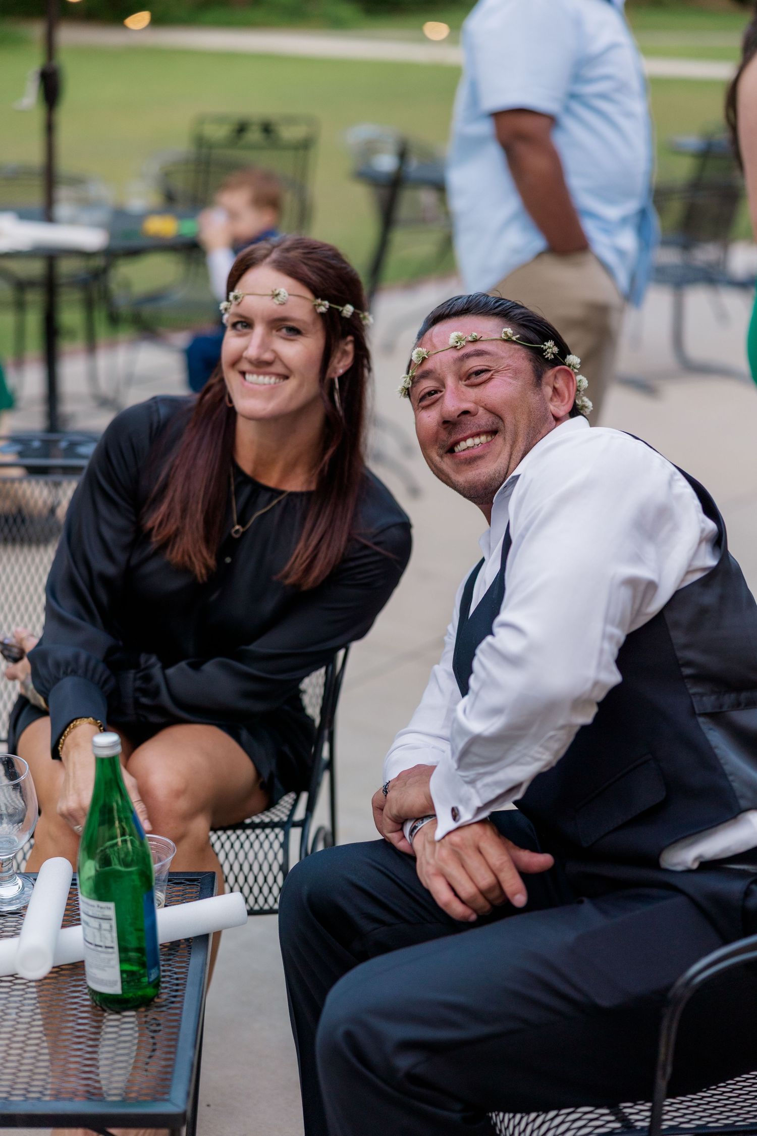 Guests enjoying candid moments at outdoor seating during wedding reception.