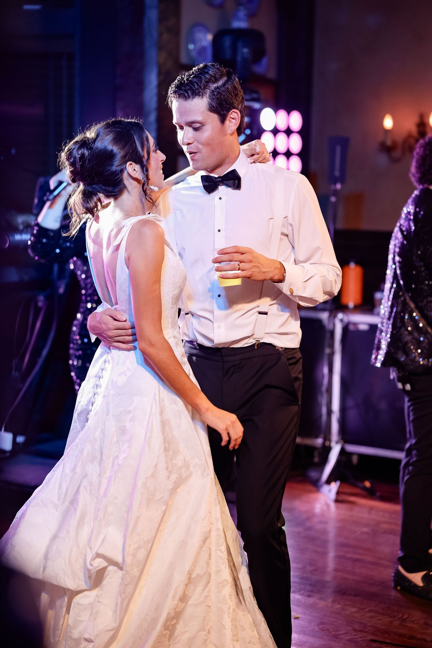 Bride and groom share an intimate dance together at their wedding reception with a live band performing.