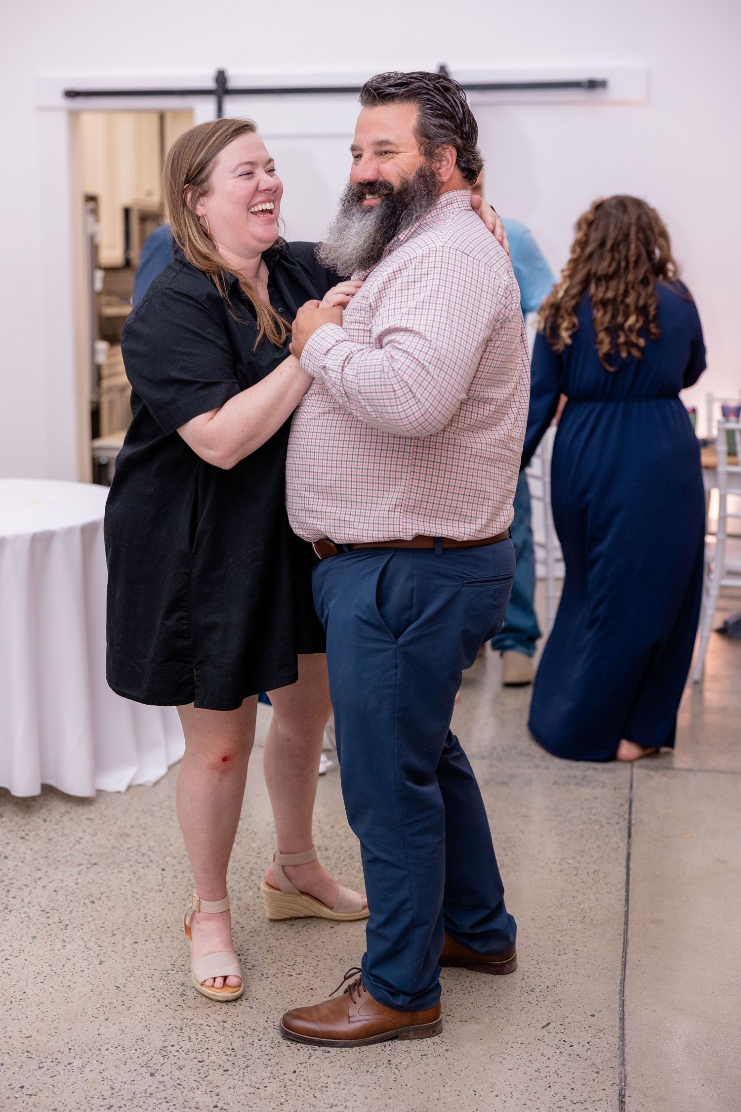 Joyful dancing moment between guests at wedding reception.