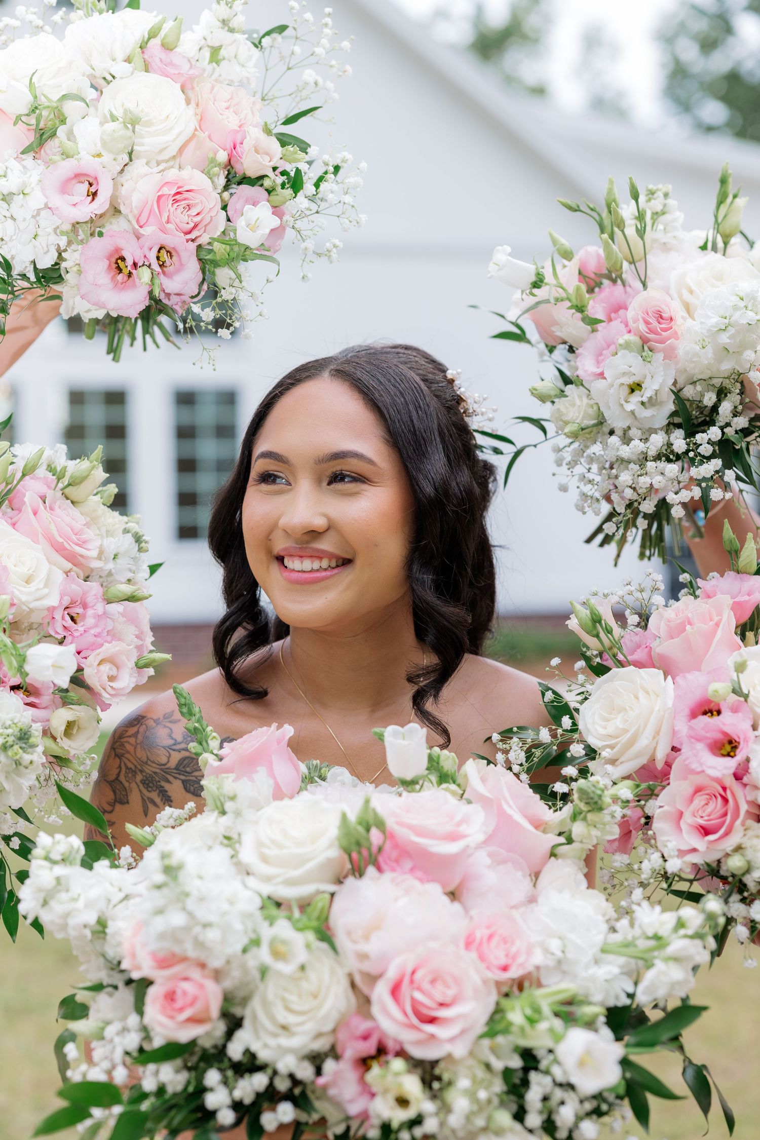 Beautiful pink and white rose bouquet arrangement with baby's breath against white backdrop.