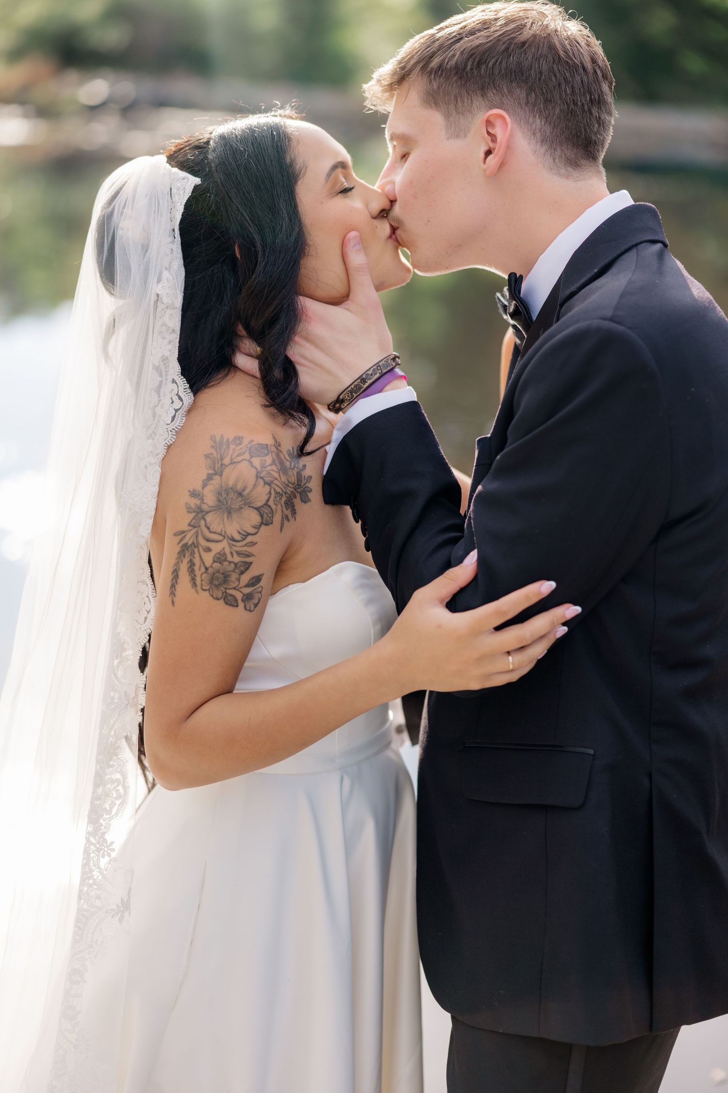 Intimate wedding portrait captured during couple's first kiss outdoors.