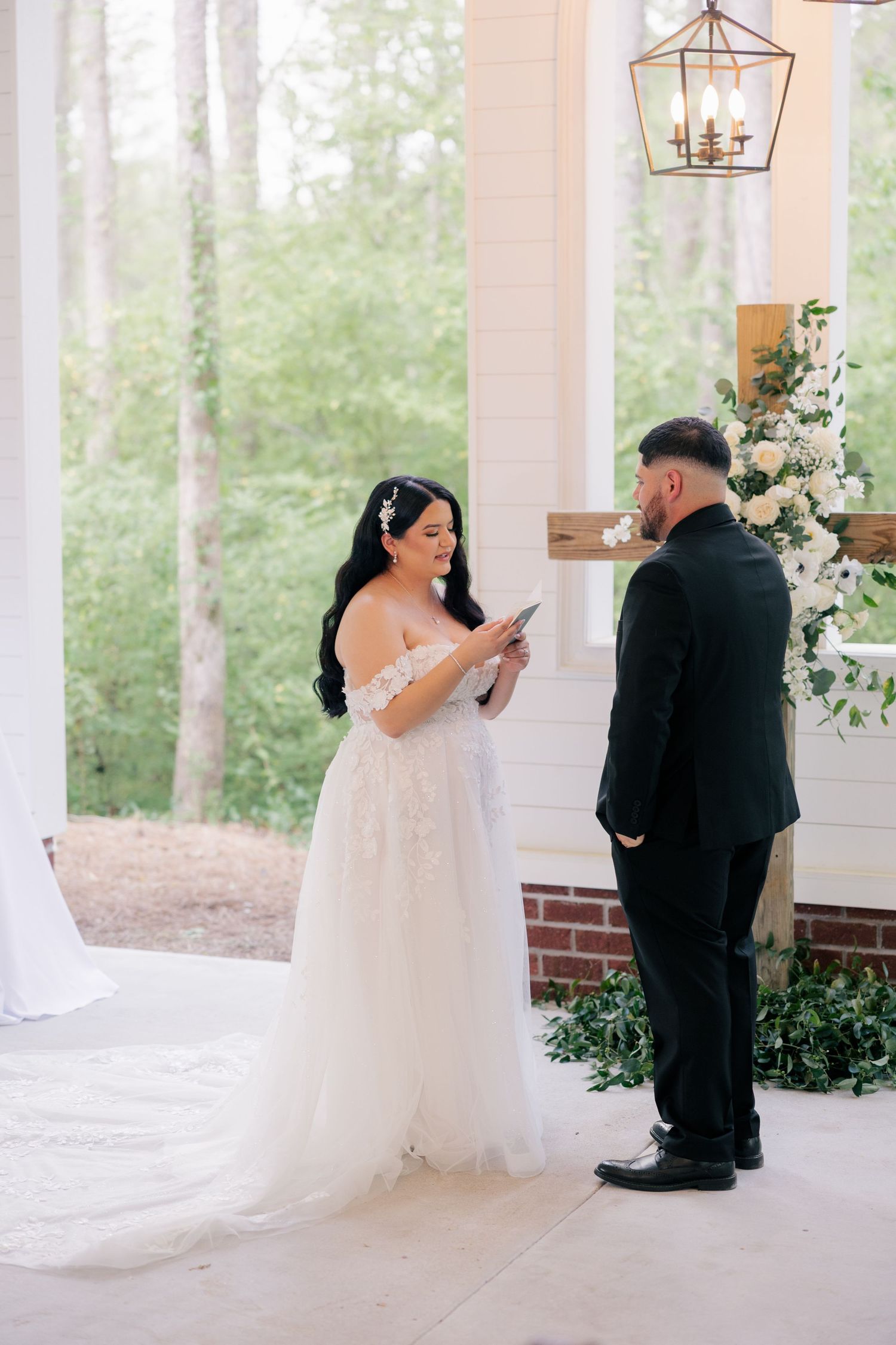 A touching first look moment captured on a white columned porch during a wedding ceremony.