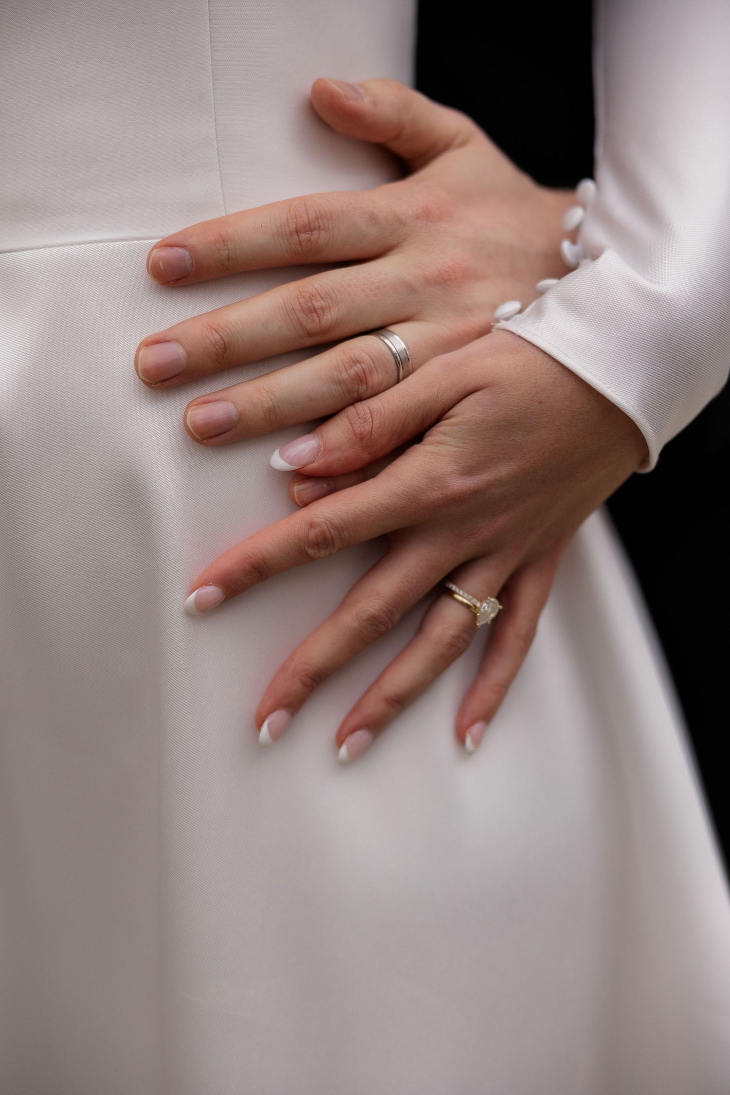 Detail shots showing wedding rings and hands against white fabric in sequence.