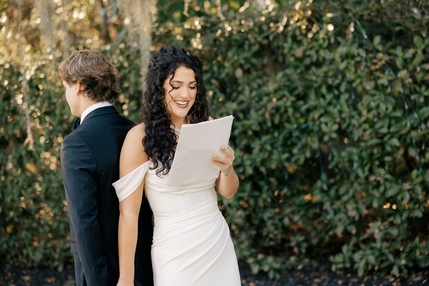 A couple shares a private moment while reading a letter together before their wedding ceremony.