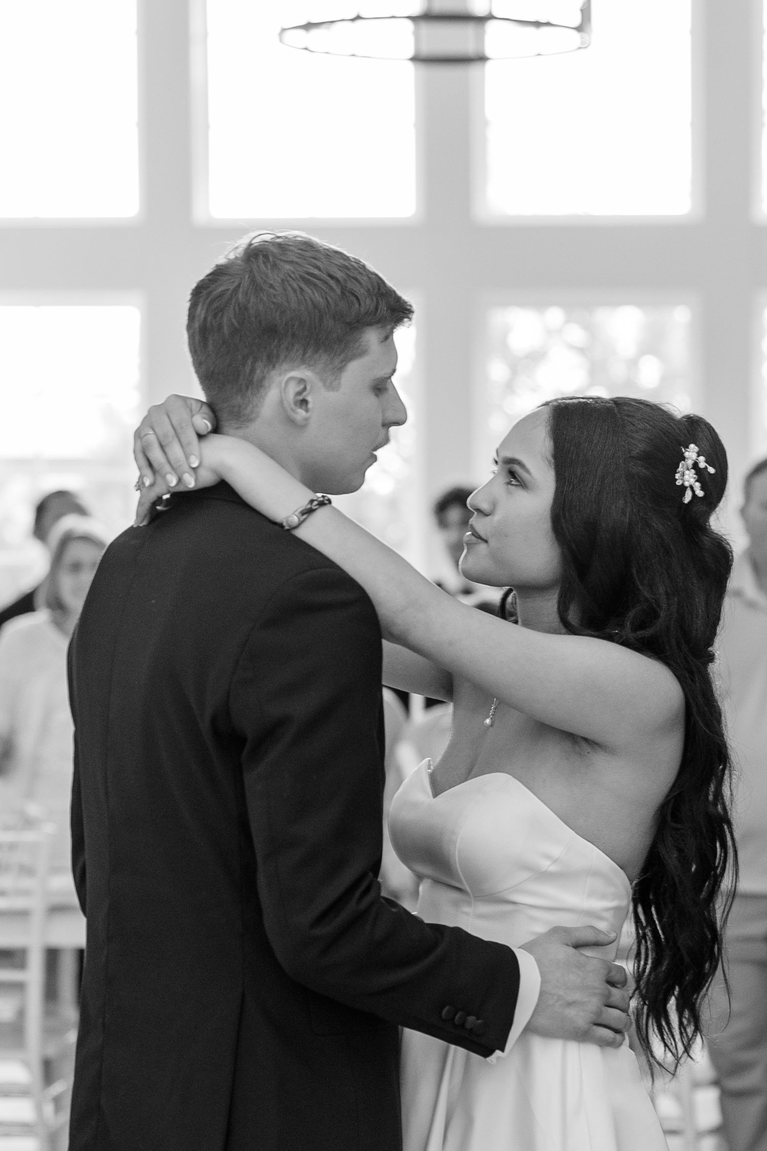 Couple sharing a romantic dance moment in a brightly lit ballroom.