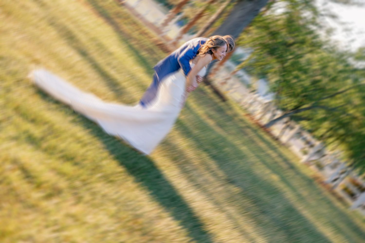 Artistic spinning aerial shot of bride and groom dancing outdoors at wedding reception.