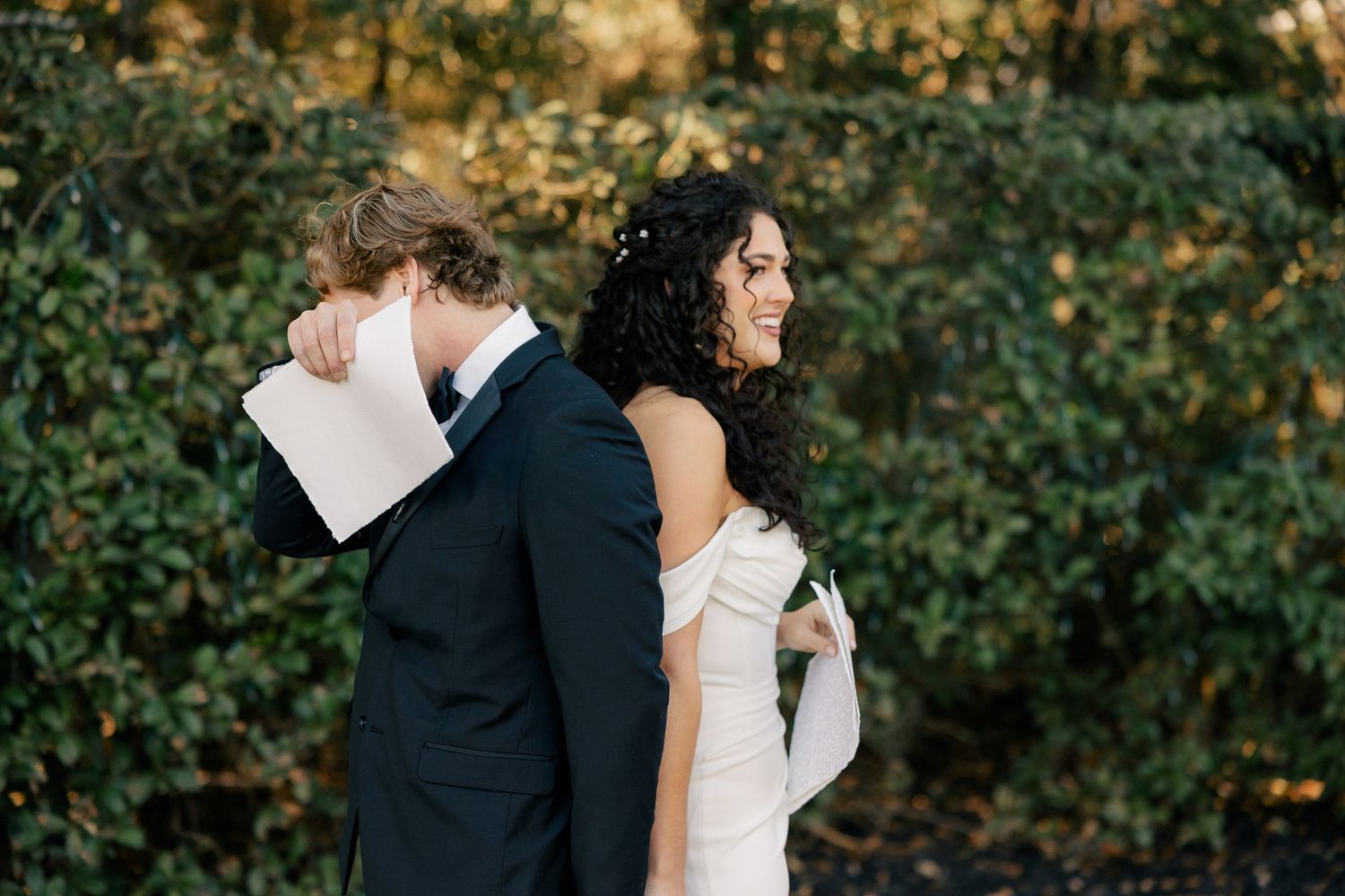 Couple stands back to back during romantic outdoor wedding photo session.