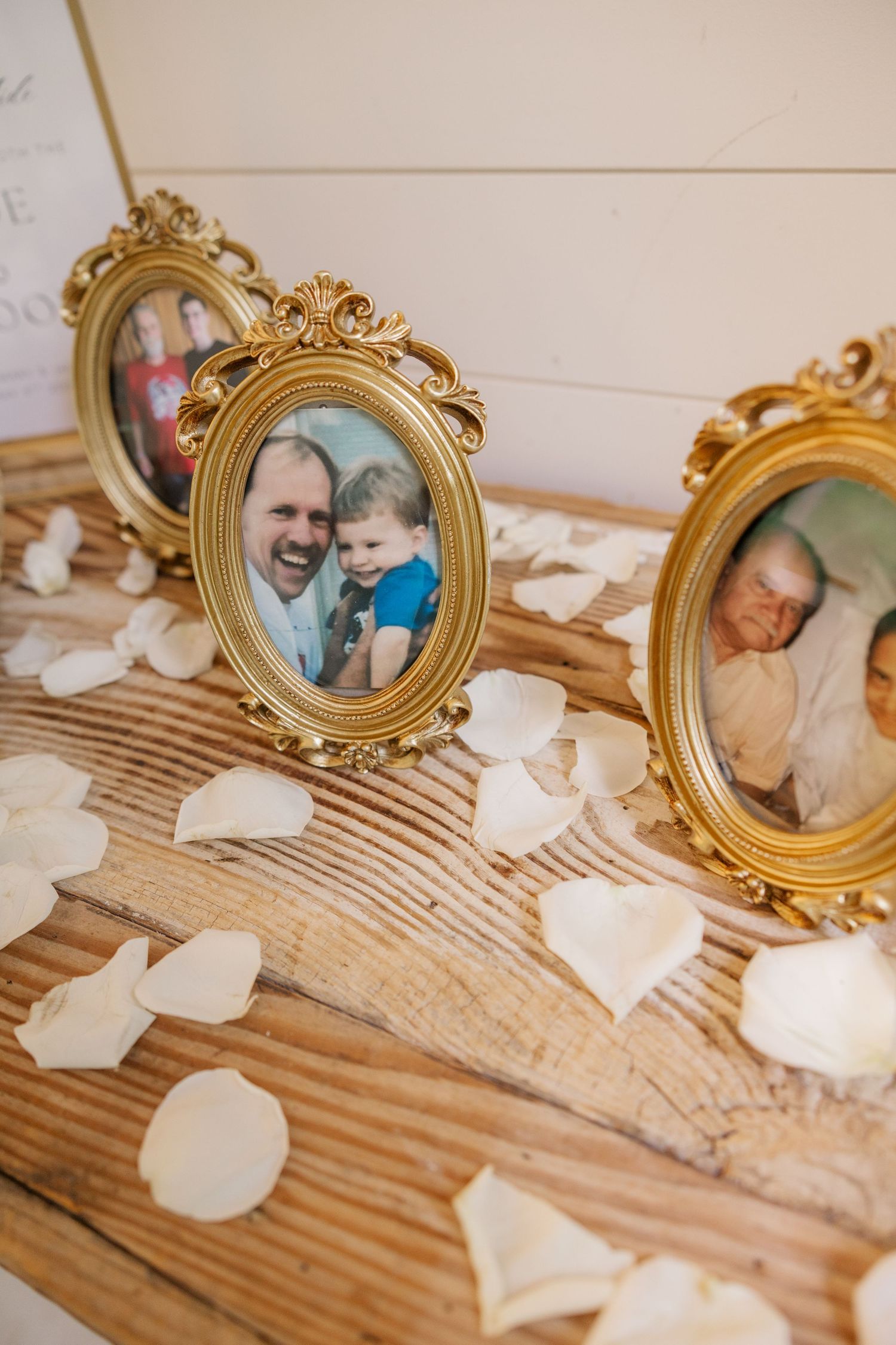Vintage gold frames and paper hearts create a rustic wedding decoration display on wooden surface.