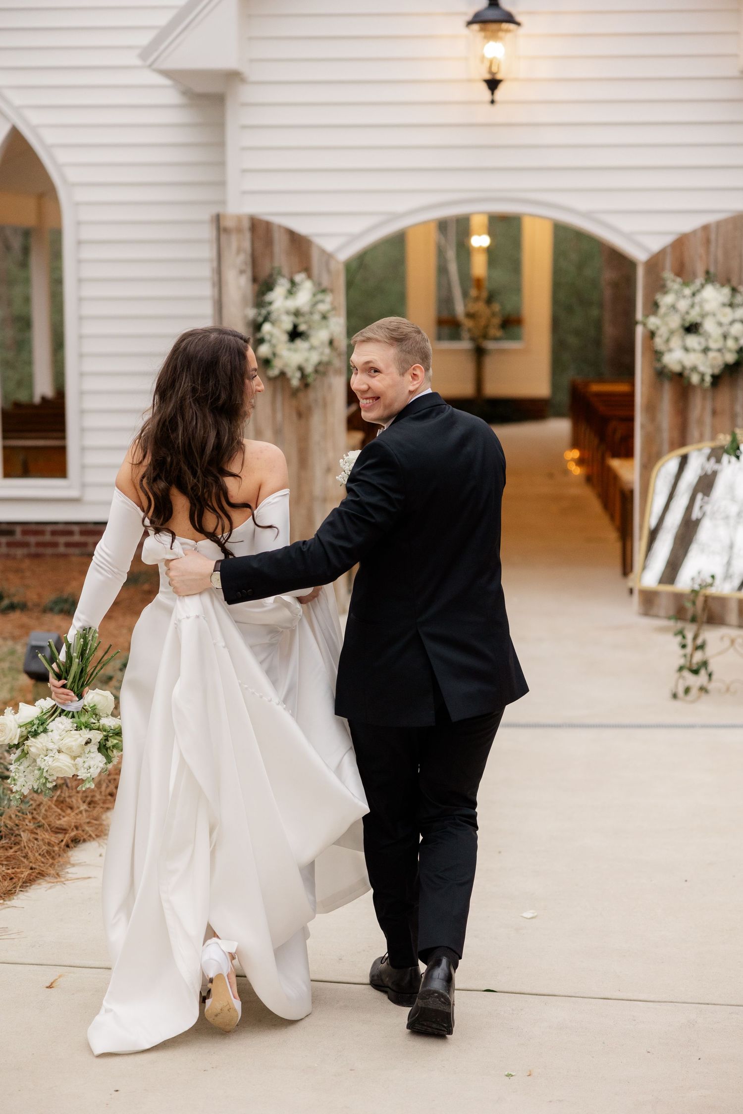 Wedding couple shares intimate dance moves on a white stone patio outside their venue.