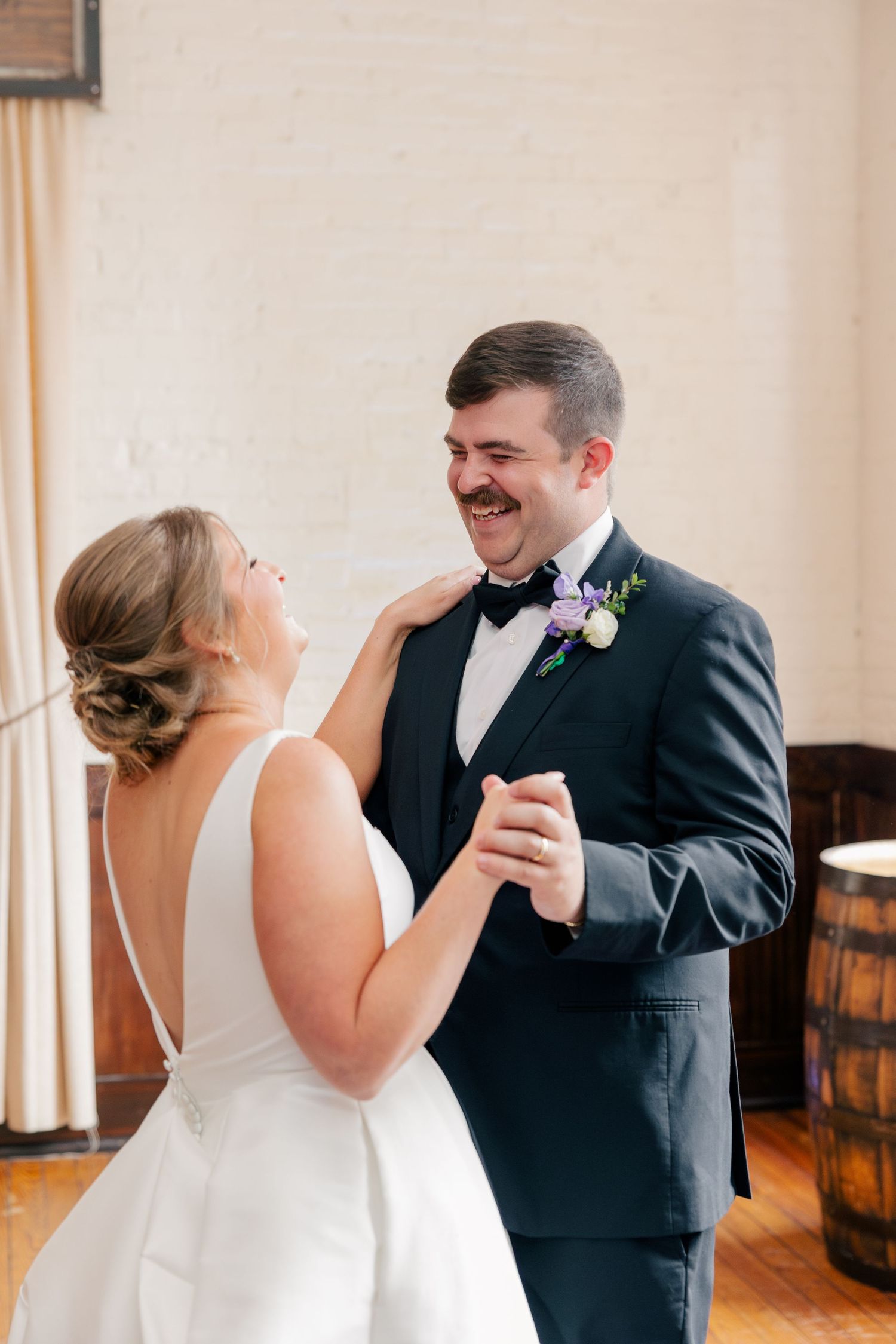 Bride and groom sharing joyful first dance at wedding reception.