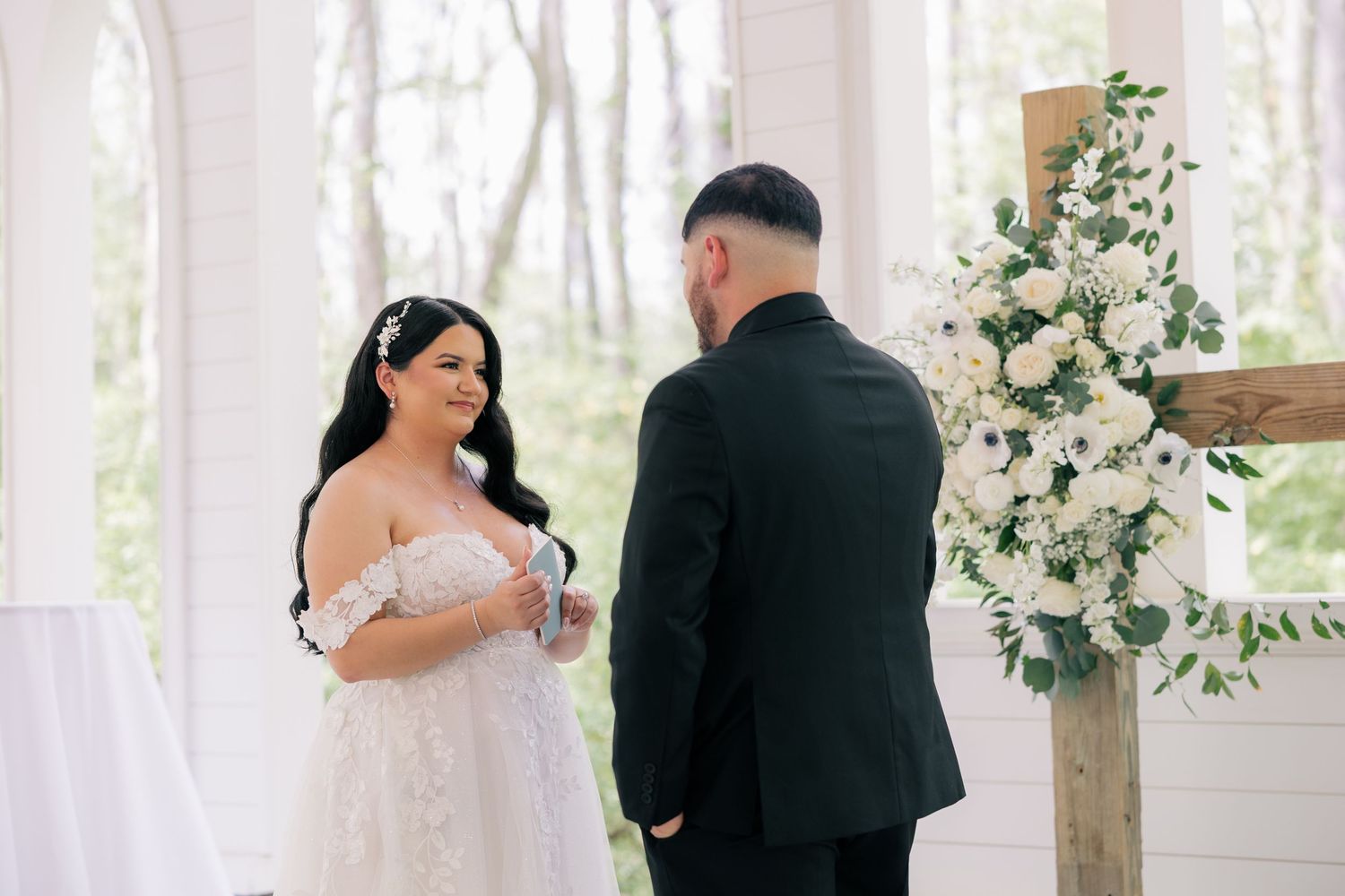 Wedding couple sharing a romantic dance moment in a bright sunlit venue with floral decorations.