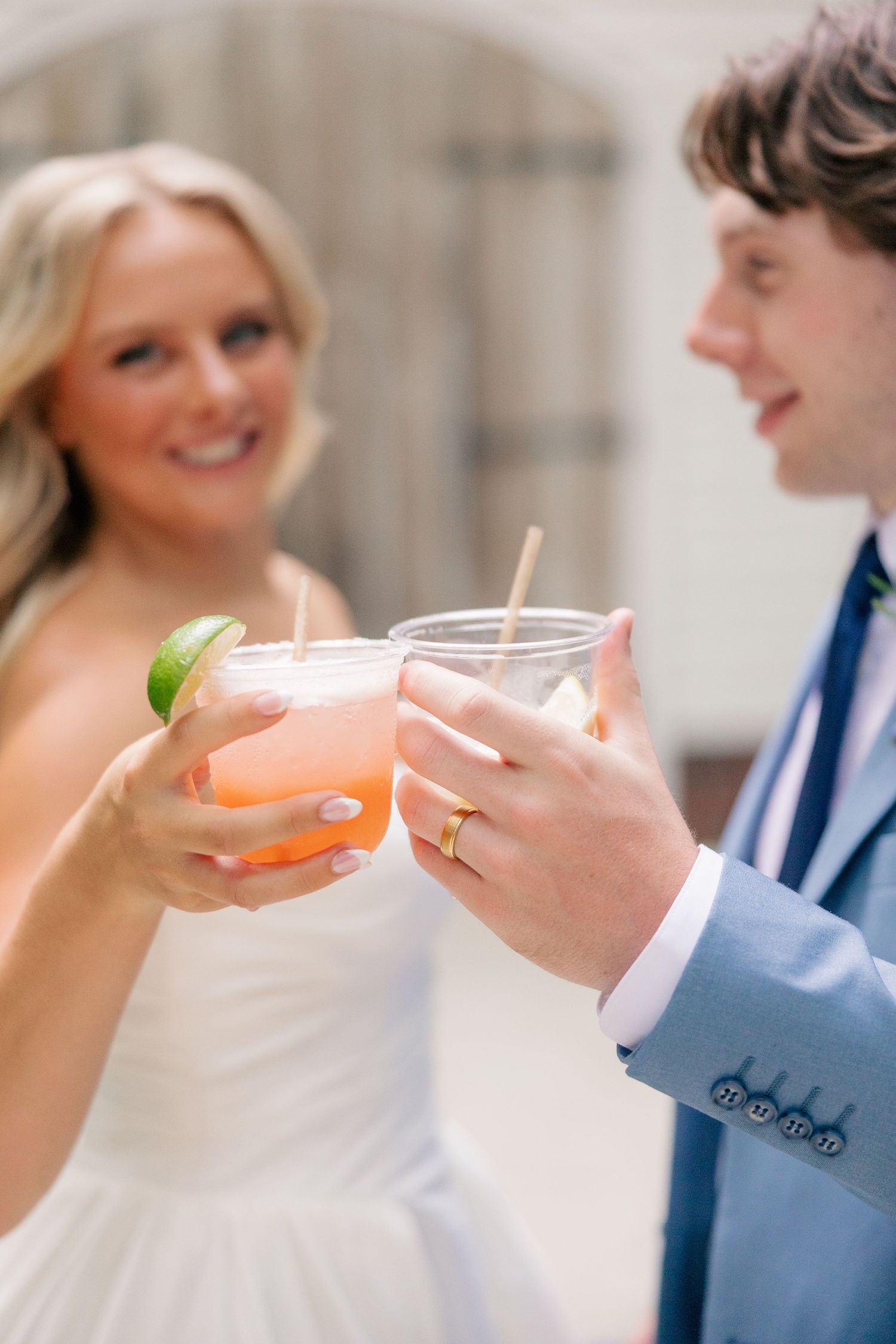 Bride and groom toasting with colorful cocktails during their outdoor wedding celebration.