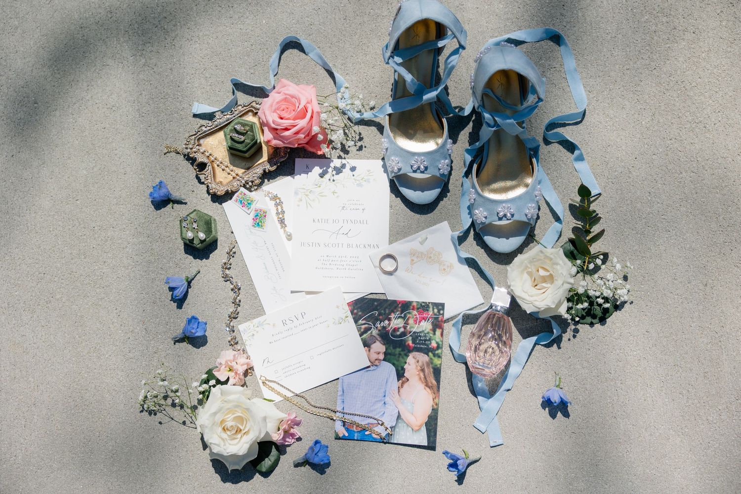 Overhead view of people in blue dresses sitting on ground looking at papers and flowers.