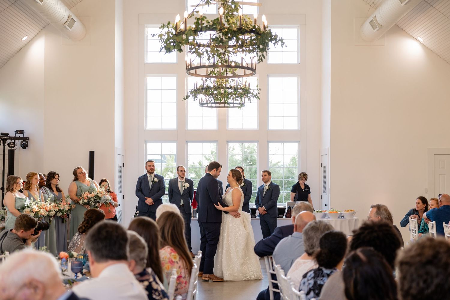 Wedding reception venue interior with elegant chandeliers and floral arrangements.