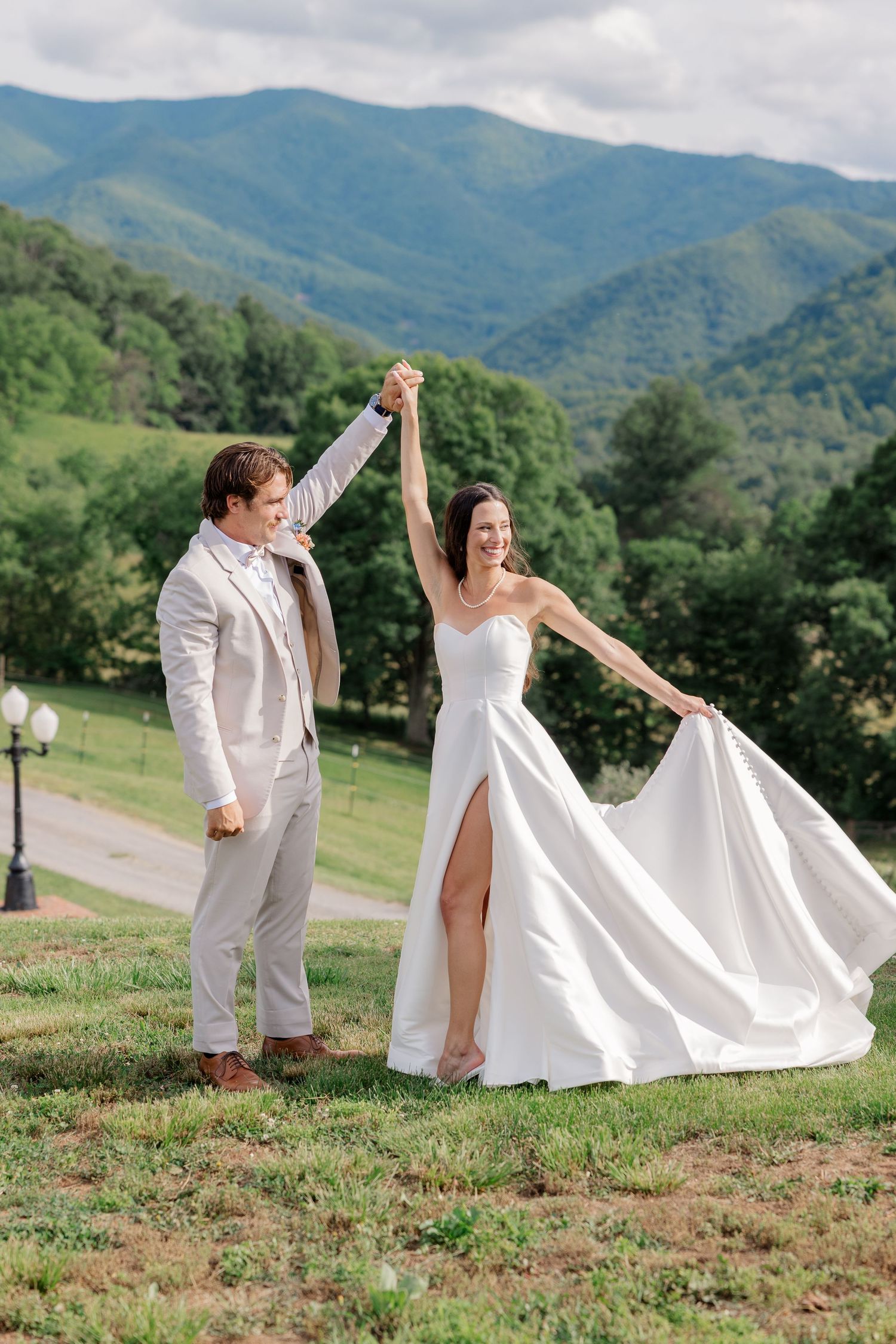 A joyful celebration with mountains and greenery in the background at an outdoor wedding venue.