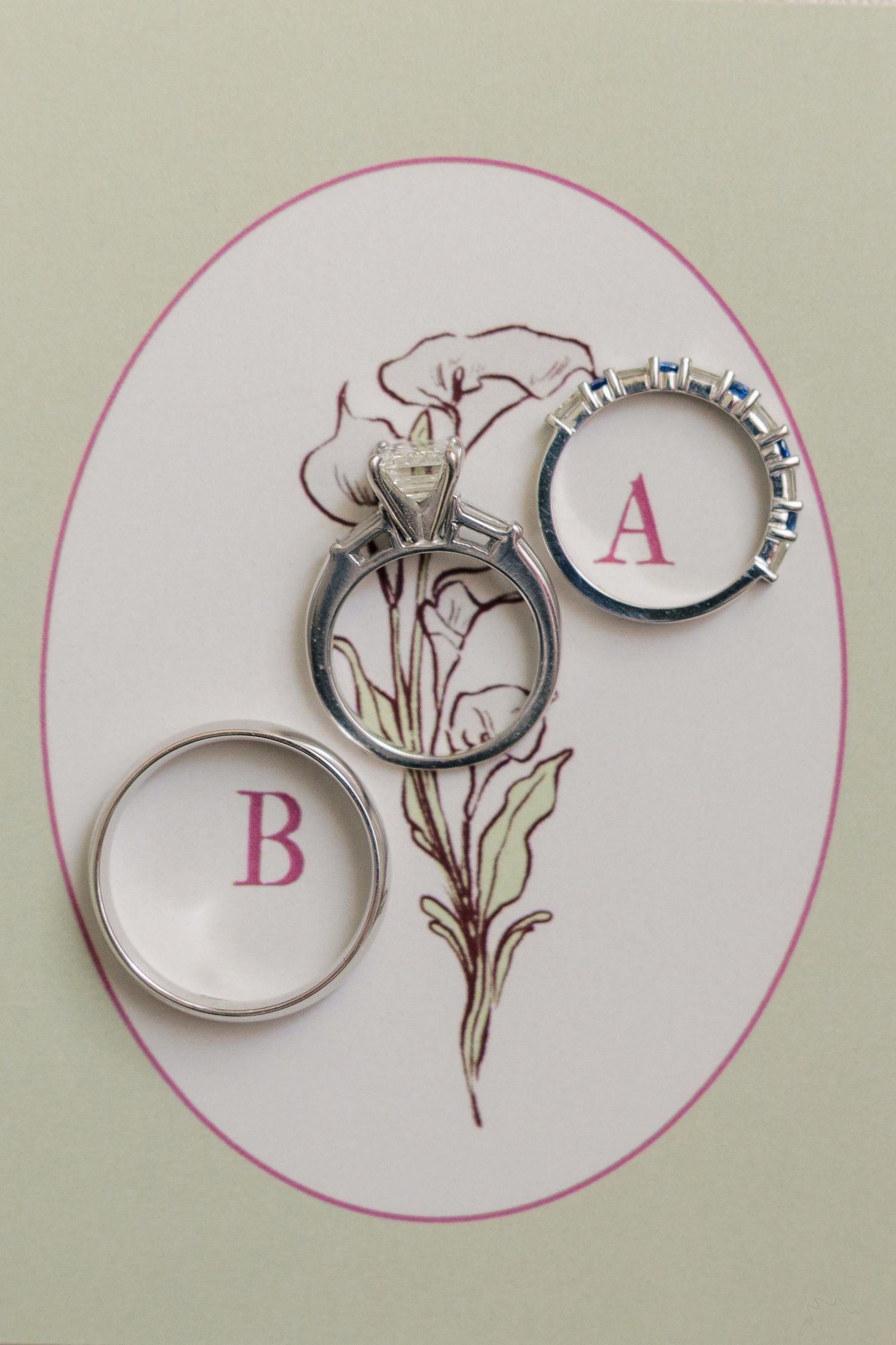 Three silver wedding rings labeled A and B displayed on a floral illustrated card.