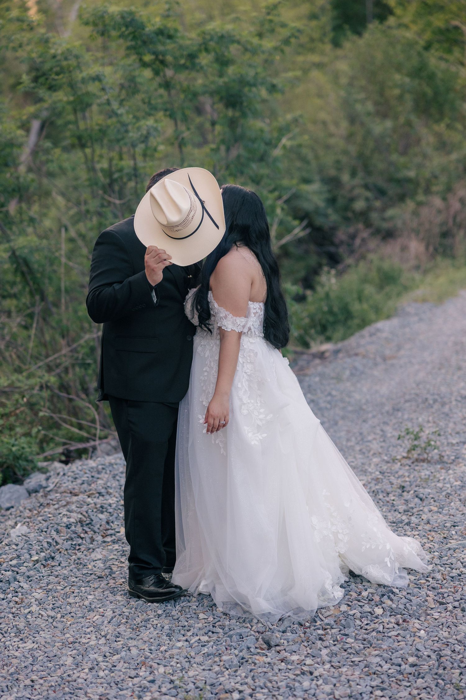 Intimate wedding couple moments photographed on a rocky lakeside path.