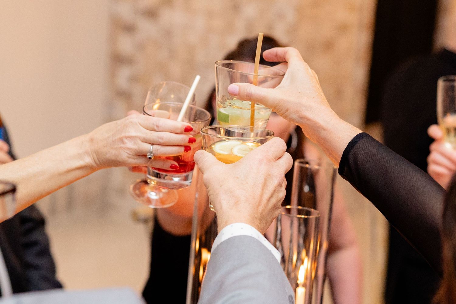 Wedding guests toast with colorful cocktails during an elegant reception celebration.