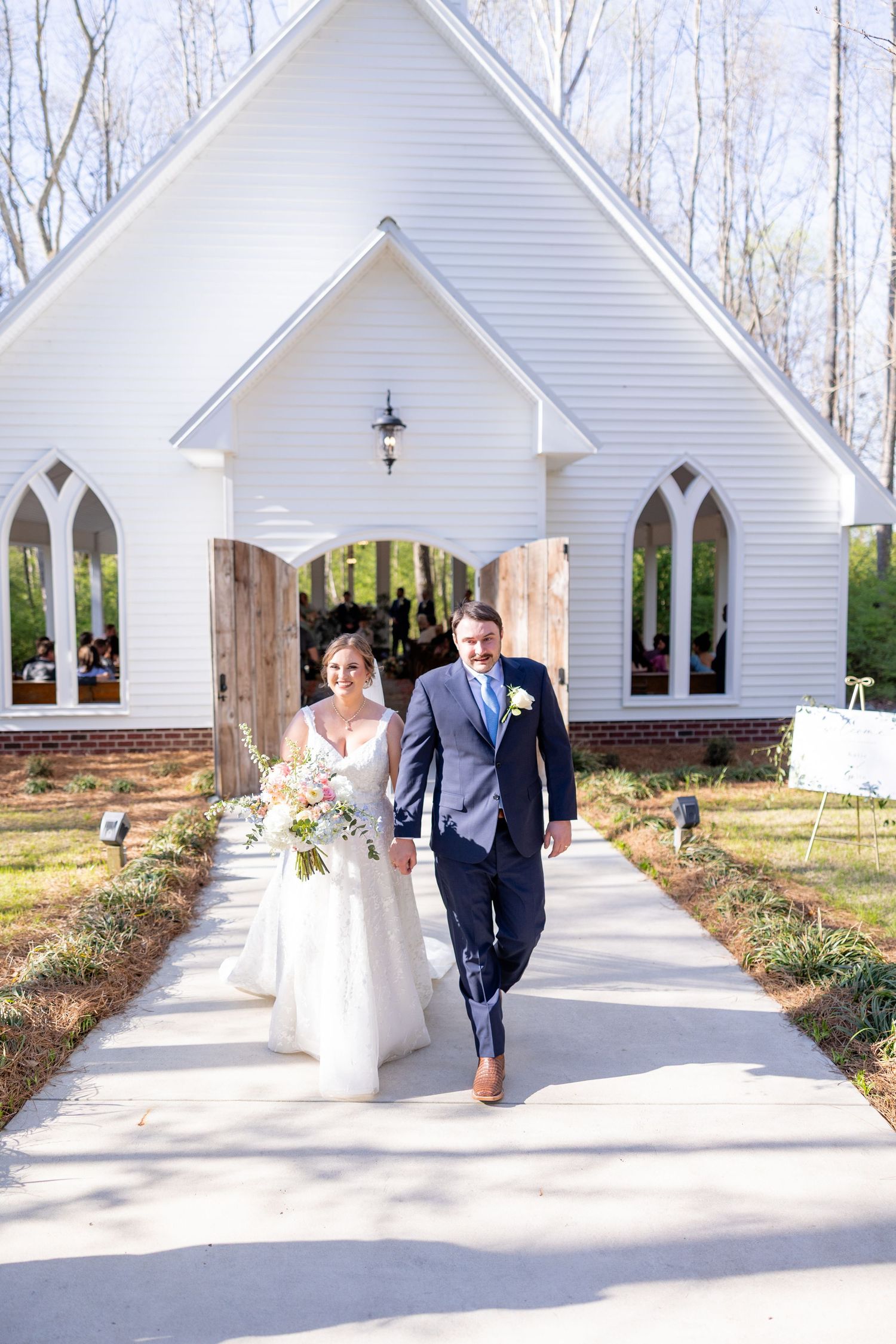 A white chapel wedding venue sequence with multiple arched windows and walkways captured in winter.