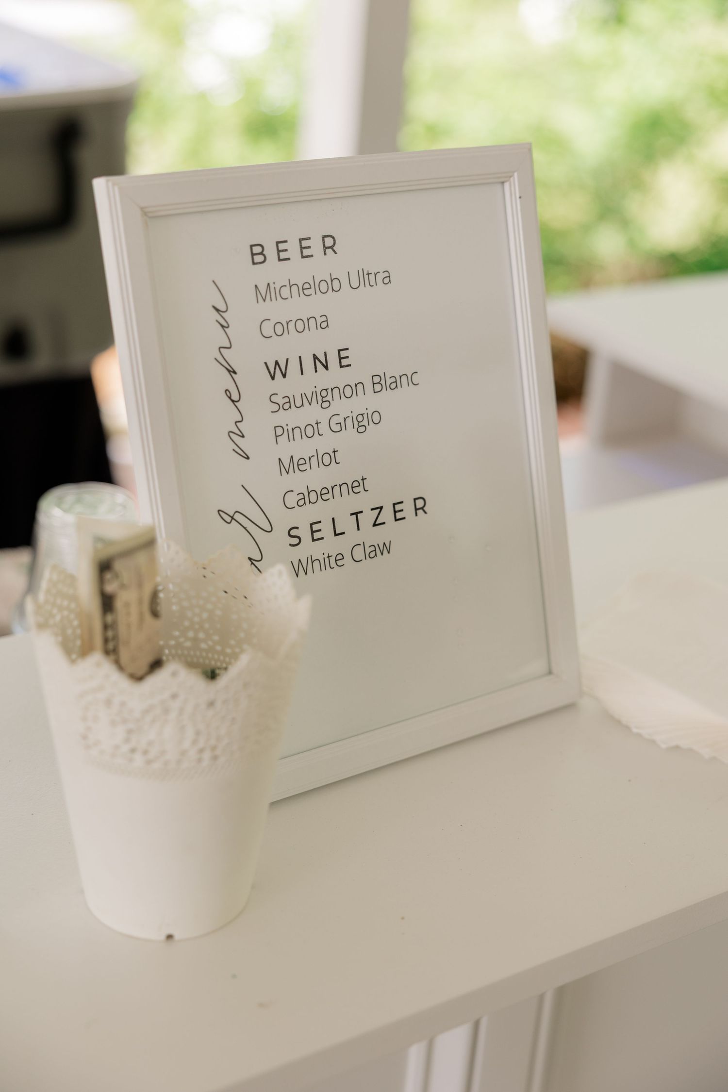 Wedding bar menu sign displays beer, wine and seltzer options on white paper.