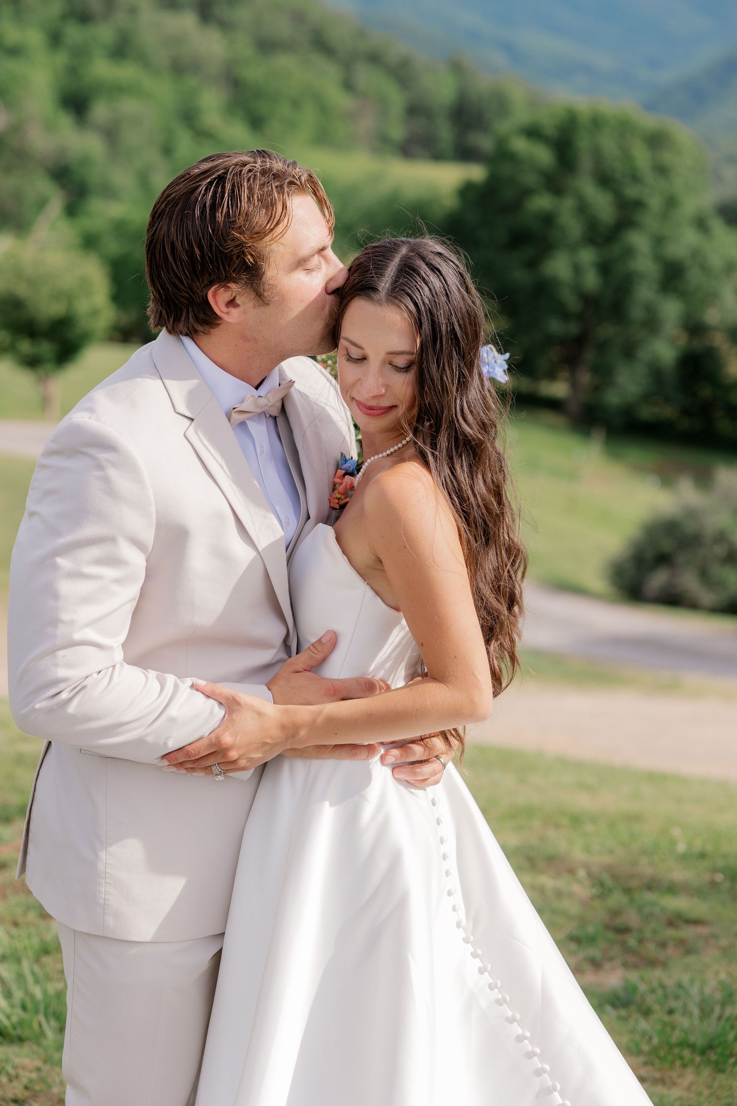 A romantic wedding couple embraces and kisses in a series of photos with mountains in the background.