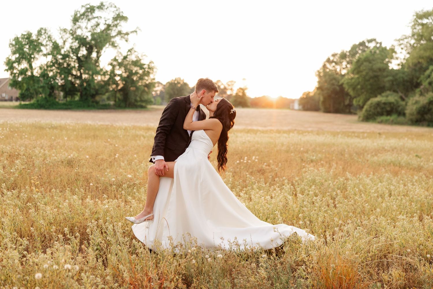 Romantic sunset wedding photos in a golden field with flowing white dress.